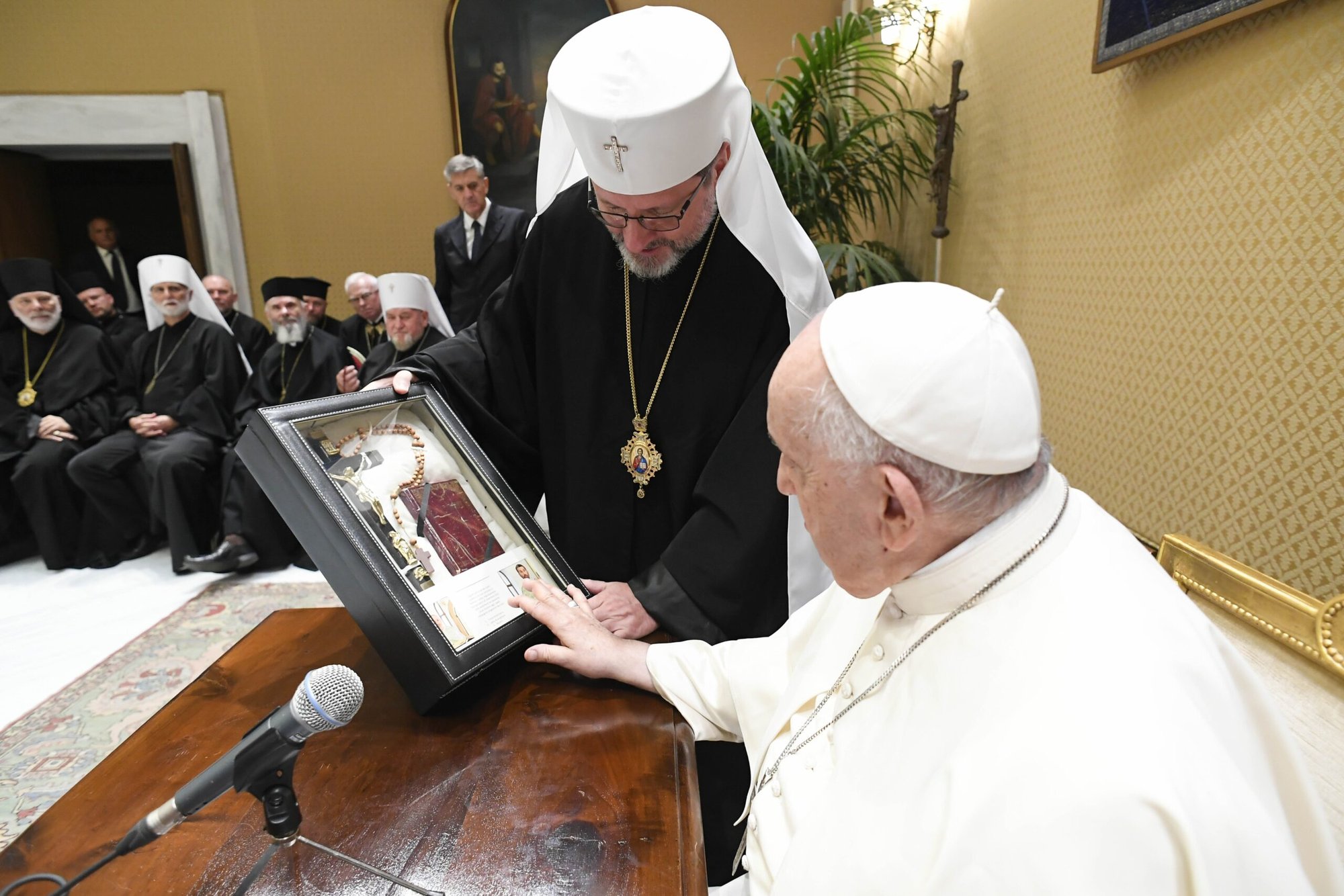 El arzobispo Sviatoslav Shevchuk, arzobispo mayor de Kyiv-Halych y cabeza de la Iglesia católica ucraniana, entrega al papa Francisco una cruz, un libro de oraciones y un rosario pertenecientes a dos sacerdotes redentoristas detenidos en territorio ucraniano ocupado por Rusia en noviembre de 2022 y que se cree que siguen bajo custodia rusa, durante una reunión del sínodo de obispos católicos ucranianos de rito oriental en una sala de reuniones del salón de audiencias del Vaticano, el 6 de septiembre de 2023. (CNS/Vatican Media)