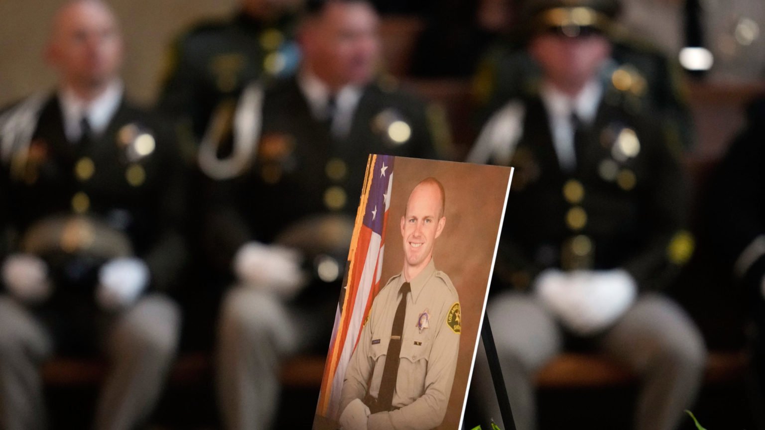 La foto del ayudante del sheriff de Los Ángeles Ryan Clinkunbroomer se coloca cerca del altar durante su misa funeral en la Catedral de Nuestra Señora de los Ángeles el jueves 5 de octubre de 2023, en Los Ángeles. Clinkunbroomer fue asesinado a tiros el 16 de septiembre mientras estaba sentado en su coche patrulla en Palmdale. (AP Photo/Ashley Landis, Pool)