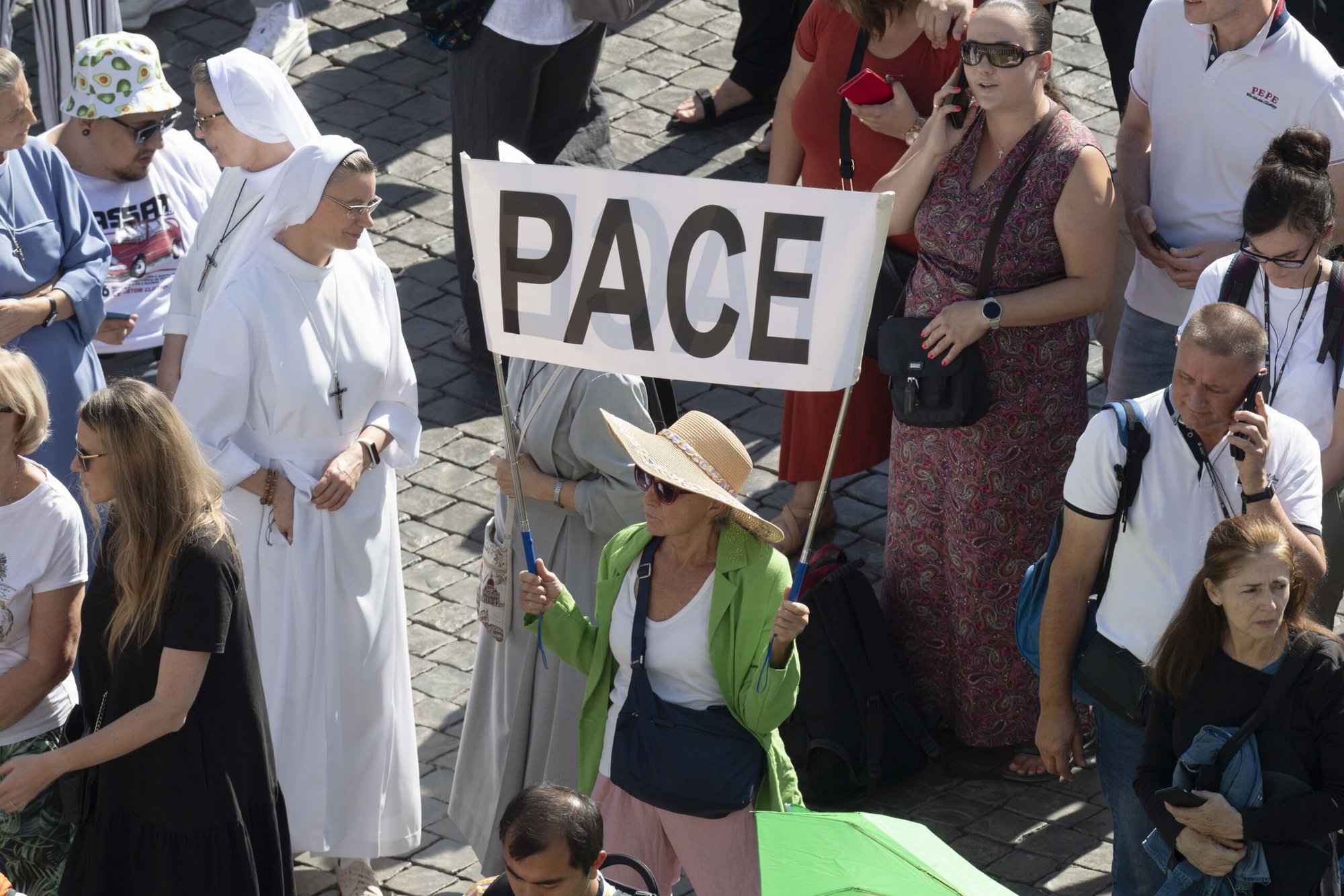 Una mujer sostiene un cartel que dice "Pace", paz en italiano, mientras el Papa Francisco pide el fin de la violencia entre Israel y Palestina después de recitar la oración del Ángelus el 8 de octubre de 2023, con los visitantes en la Plaza de San Pedro en el Vaticano. (Foto CNS/Vatican Media)