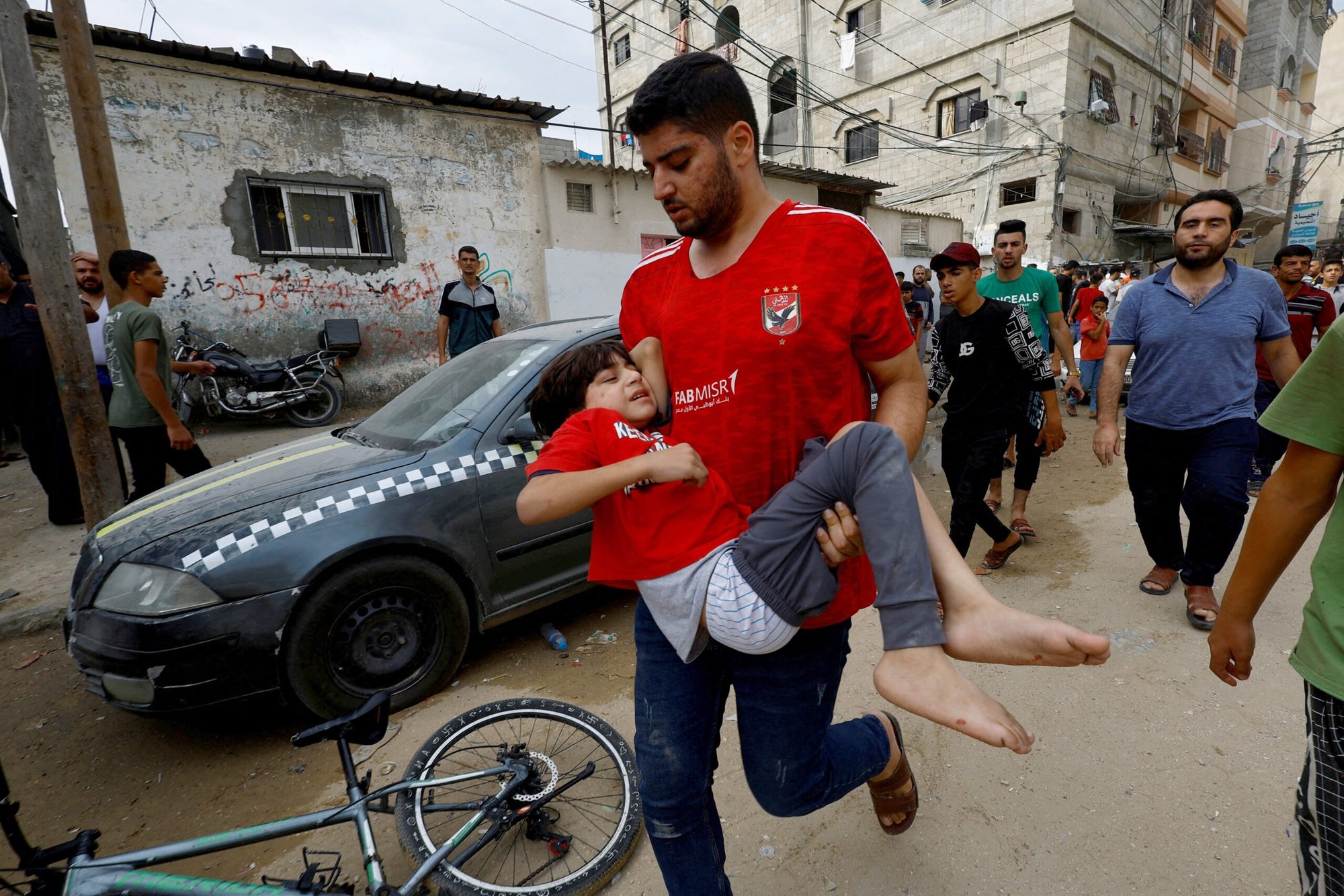 Un hombre lleva a un niño en el lugar de un ataque aéreo israelí contra una casa en Khan Younis, en el sur de la Franja de Gaza, 27 de octubre de 2023, mientras continúa el conflicto entre Israel y el grupo islamista palestino Hamás. (Foto de OSV News/Mohammed Salem, Reuters)