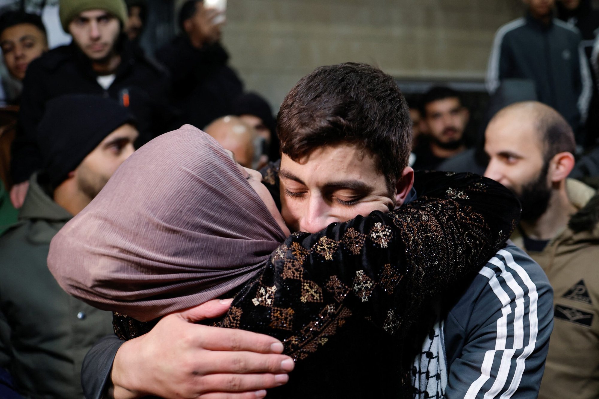 El prisionero palestino liberado Khalil Zamareh abraza a su madre el 26 de noviembre de 2023, mientras es recibido por su familia fuera de su casa cerca de Hebrón, en la Cisjordania ocupada por Israel, en medio de un acuerdo de intercambio de rehenes-prisioneros entre Hamás e Israel. (Foto de OSV News/Mussa Qawasma, Reuters)