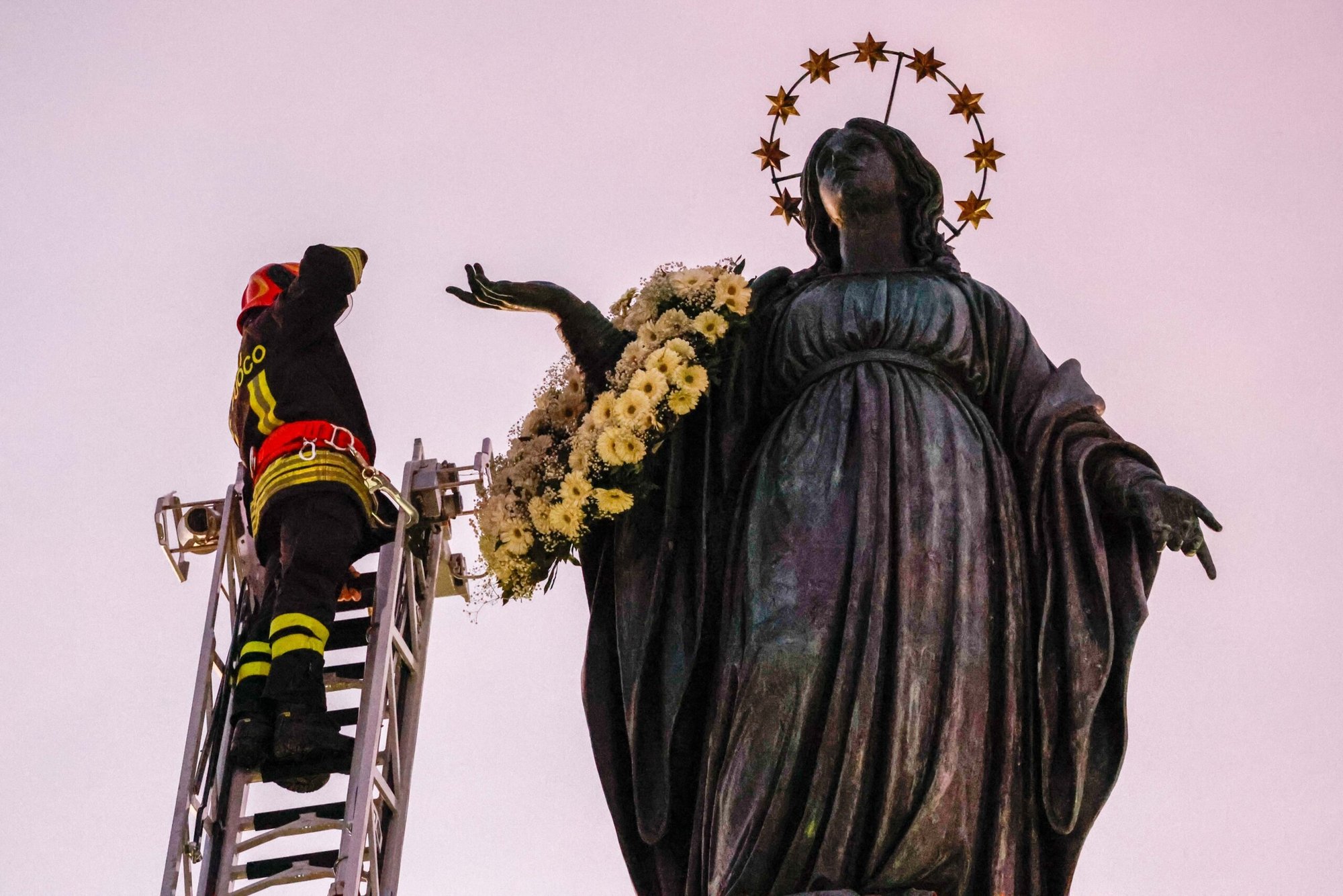 Un bombero saluda a María después de colocar una corona de flores en una estatua cerca de la Plaza de España en Roma el 8 de diciembre de 2023, fiesta de la Inmaculada Concepción. El Papa Francisco iba a rezar ante la estatua ese día, continuando la tradición papal de visitar la Plaza de España en la solemnidad de la Inmaculada Concepción. (Foto CNS/Lola Gomez)