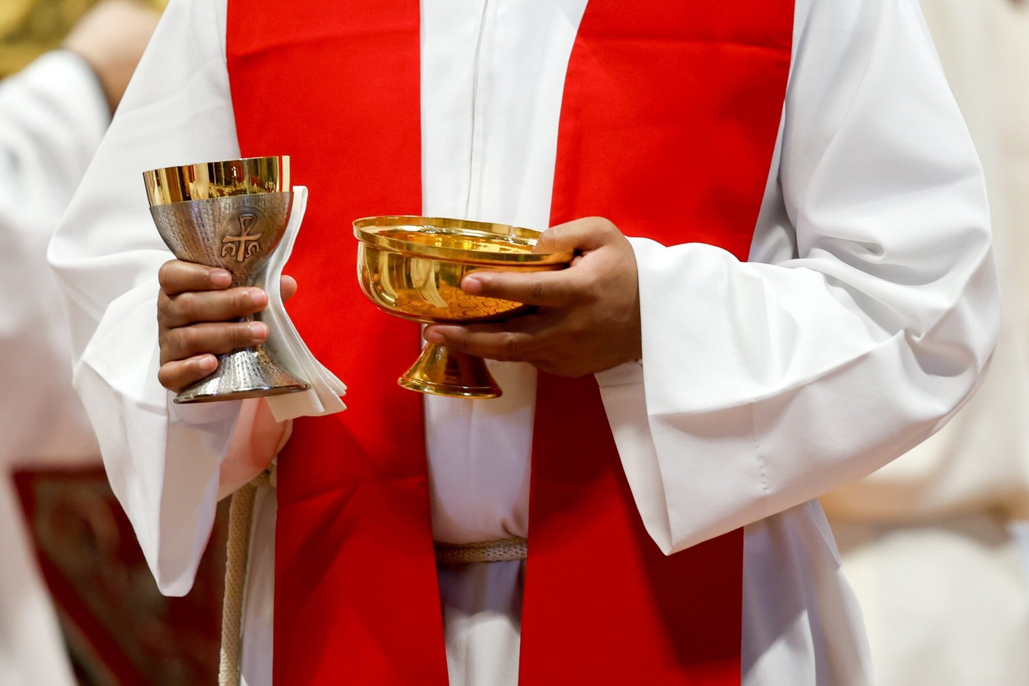 Esta ilustración fotográfica muestra a un sacerdote preparándose para distribuir la Comunión durante la Misa en la Basílica de San Pedro en el Vaticano el 29 de junio de 2023. (Foto CNS/Lola Gomez)
