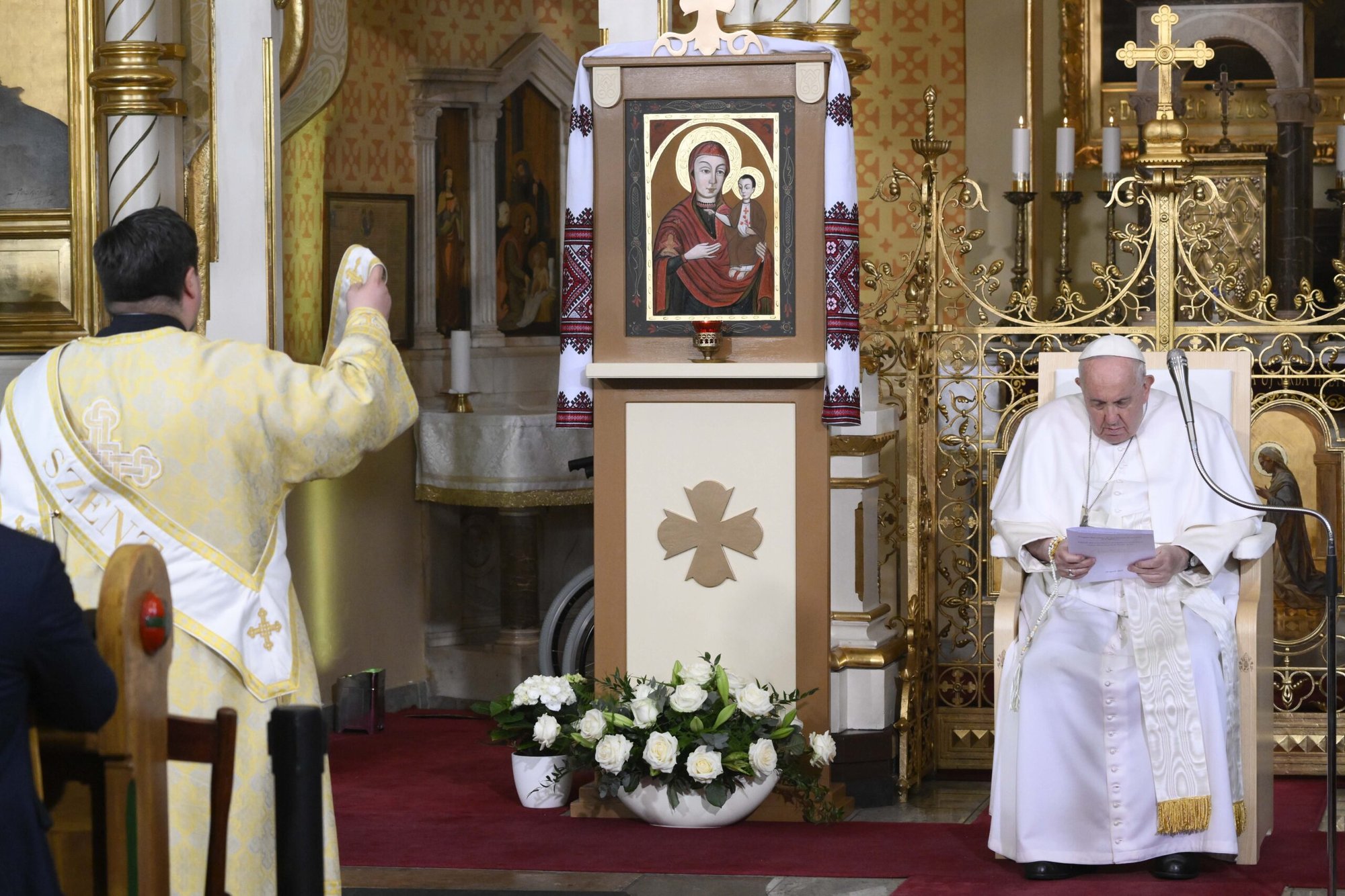 Un diácono reza delante de un icono mientras el Papa Francisco visita la Iglesia Católica Oriental de la Protección de la Madre de Dios en Budapest, Hungría, 29 de abril de 2023. (CNS /Vatican Media)