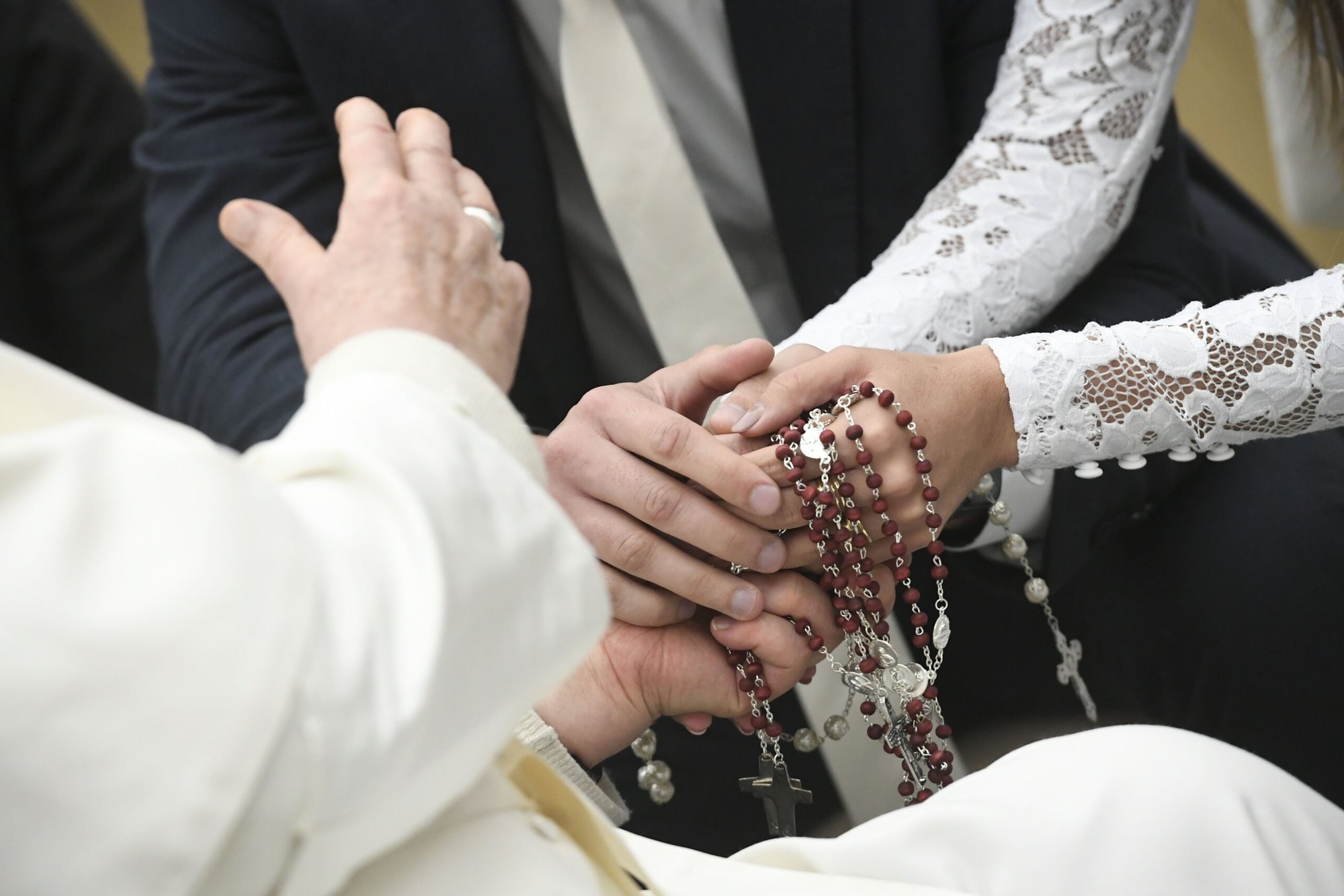 El Papa Francisco bendice rosarios sostenidos por una pareja de recién casados al final de su audiencia general en el Aula de Audiencias Pablo VI del Vaticano el 17 de enero de 2024. (Foto de CNS/Vatican Media)