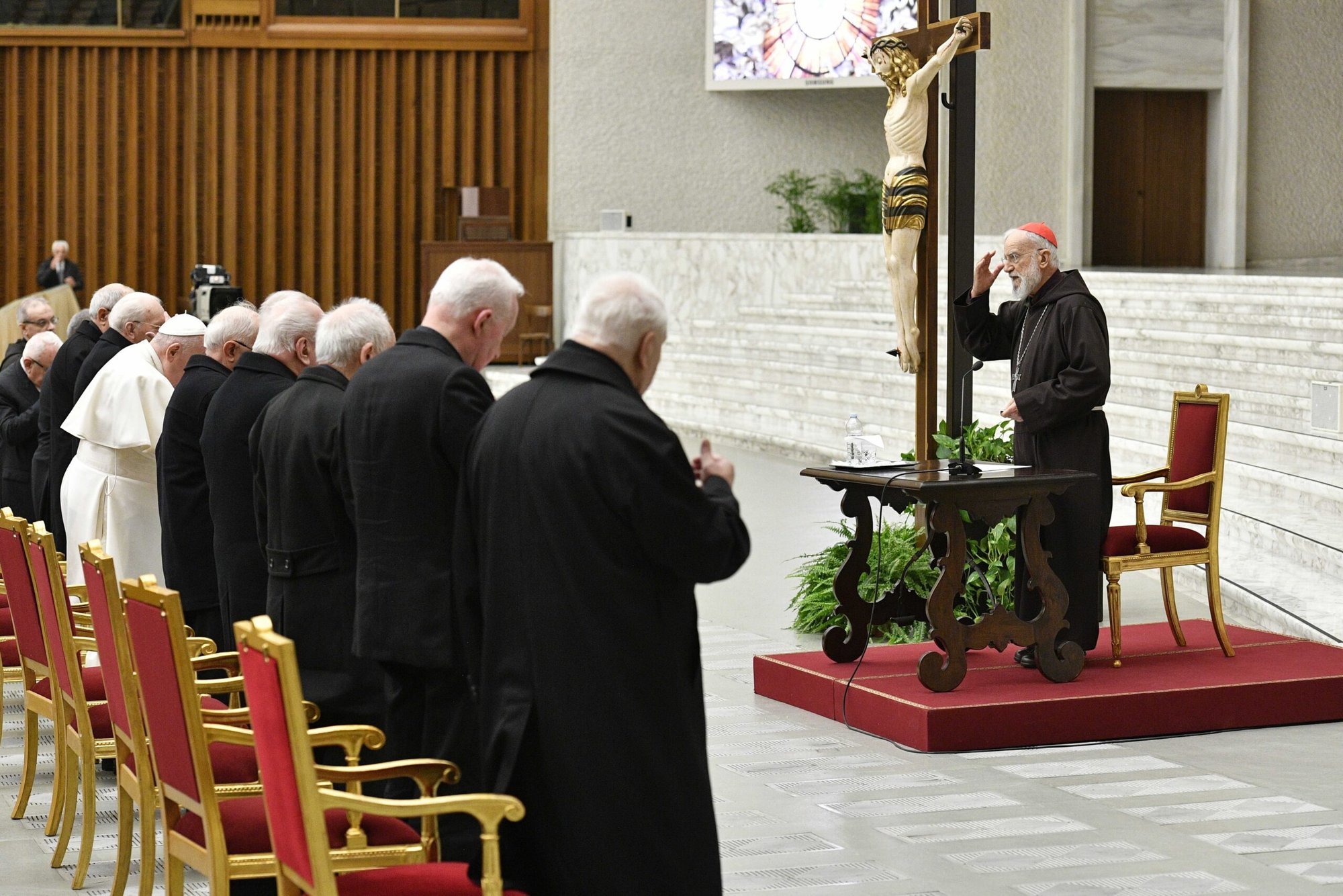 El cardenal Raniero Cantalamessa, predicador de la casa pontificia, hace la señal de la cruz antes de dirigirse al Papa Francisco y a los funcionarios de la Curia Romana durante su reflexión de Cuaresma en la sala de audiencias del Vaticano el 24 de marzo de 2023. (CNS /Vatican Media)