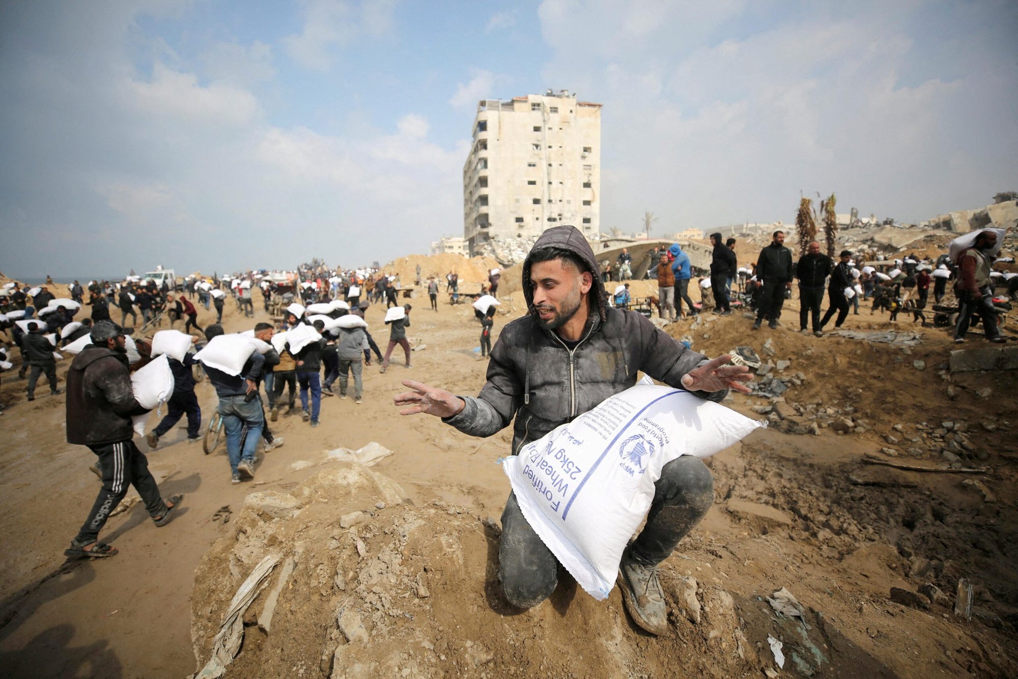 Palestinos llevan bolsas de harina que cogieron de un camión de ayuda cerca de un puesto de control israelí en la ciudad de Gaza, 19 de febrero de 2024. Los residentes de Gaza se enfrentan a niveles críticos de hambre, en medio del actual conflicto entre Israel y Hamás. (Foto de OSV News/Kosay Al Nemer, Reuters)