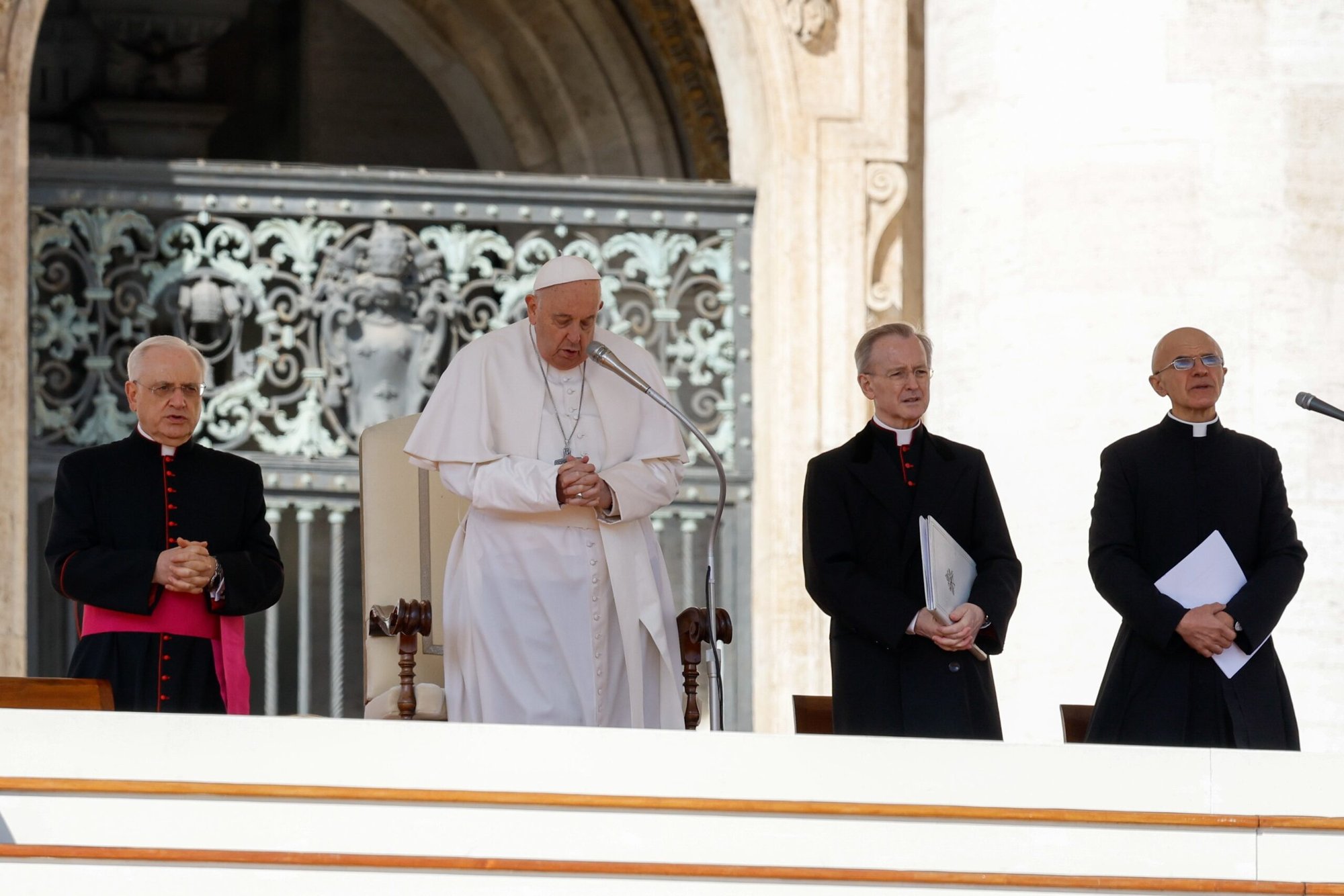 El Papa Francisco se prepara para dar su bendición al final de su audiencia semanal en la Plaza de San Pedro del Vaticano el 20 de marzo de 2024. Monseñor Leonardo Sapienza, a la izquierda, funcionario de la Prefectura de la Casa Pontificia, monseñor Luis María Rodrigo Ewart y monseñor Pierluigi Giroli rezan con el Papa. (Foto CNS/Lola Gomez)