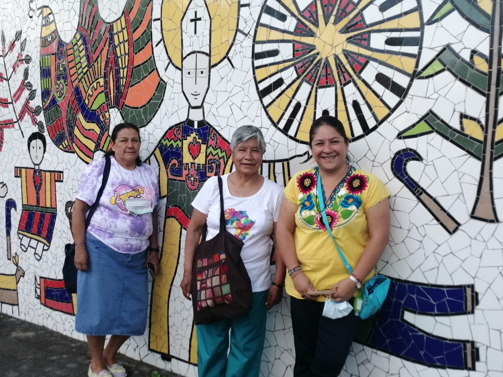 La hermana Zaira Gutiérrez, a la derecha con camisa amarilla, posa para una foto con otras Apostólicas del Corazón de Jesús delante de una obra de arte que representa a San Óscar Romero en noviembre de 2022 en San Salvador. La hermana Zaira dijo que la vida de San Romero influyó en su vocación y compromiso con los pobres. (OSV News /Rhina Guidos, Global Sisters Report)