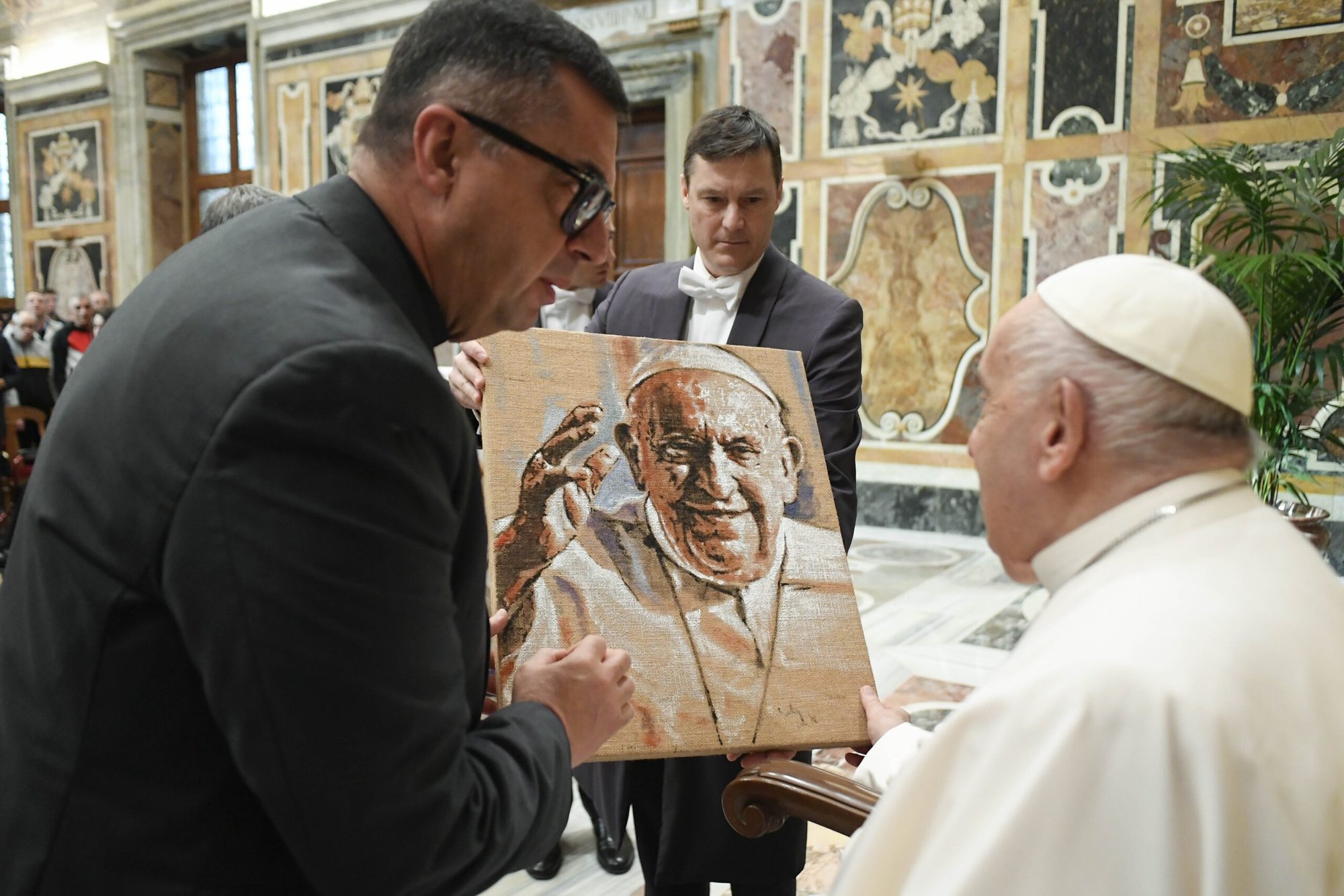El Papa Francisco recibe un cuadro suyo al final de una audiencia con personas relacionadas con la fundación Santa Ángela Merici de Siracusa, Italia, en el Palacio Apostólico del Vaticano el 6 de abril de 2024. (CNS /Vatican Media)