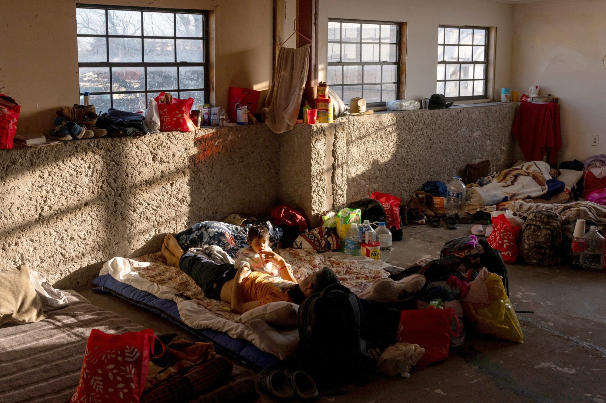 Fermín Brito, de 50 años, acaricia la barbilla de su hija de 2 años, María, mientras yacen en la cama dentro de un refugio para migrantes el 25 de febrero de 2024, en Piedras Negras, en el estado mexicano de Coahuila. Brito, su mujer y su hija huyeron de su casa en el estado mexicano de Guerrero después de que miembros de un cártel comenzaran a extorsionarles y amenazarles con violencia. (Foto OSV News/Cheney Orr, Reuters)