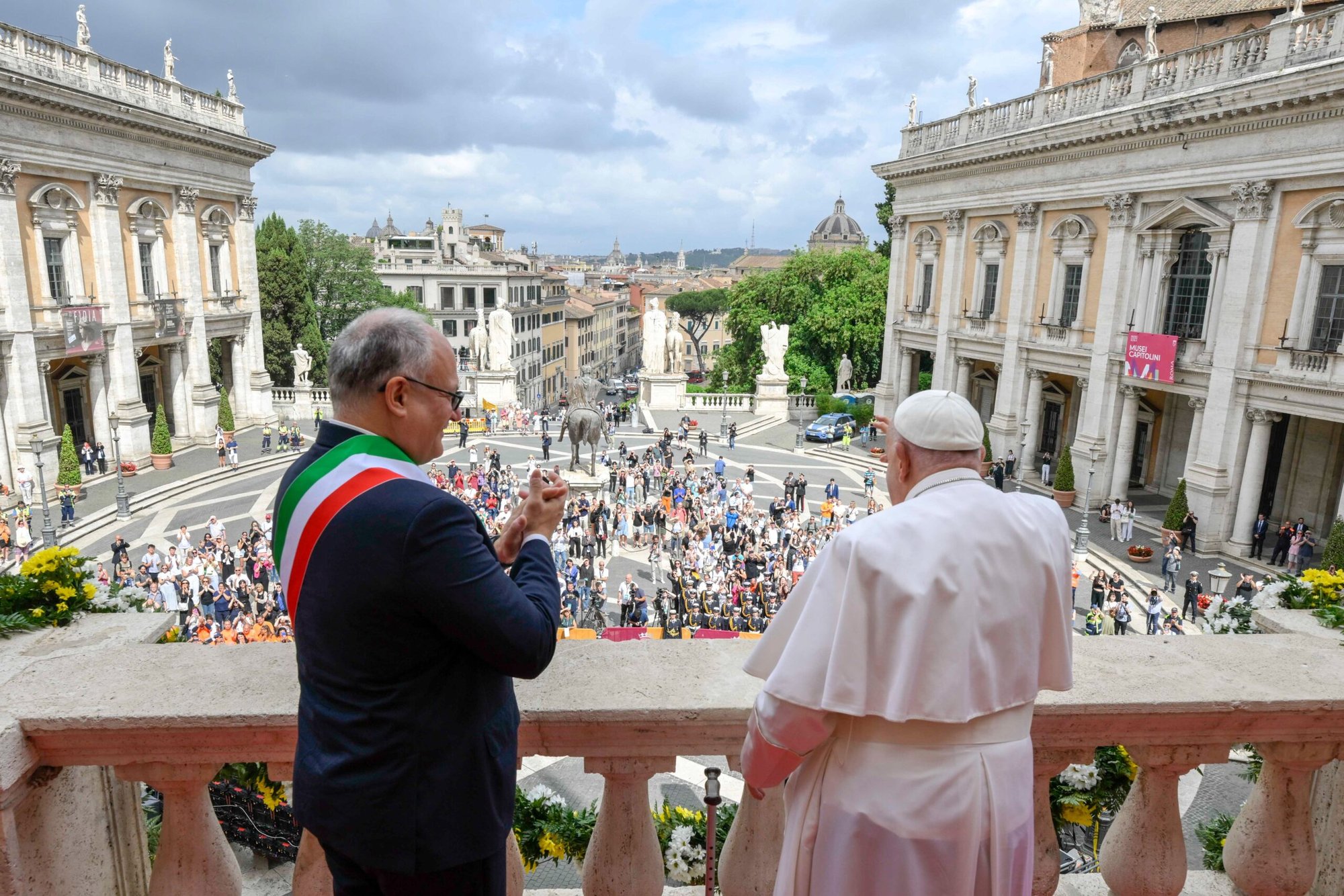El Papa Francisco saluda a los trabajadores de la ciudad y a los visitantes reunidos en la plaza del Campidoglio mientras el alcalde de Roma, Roberto Gualtieri, aplaude en la logia del edificio senatorial durante la visita del Papa al Ayuntamiento de Roma el 10 de junio de 2024. (CNS photo/Vatican Media)