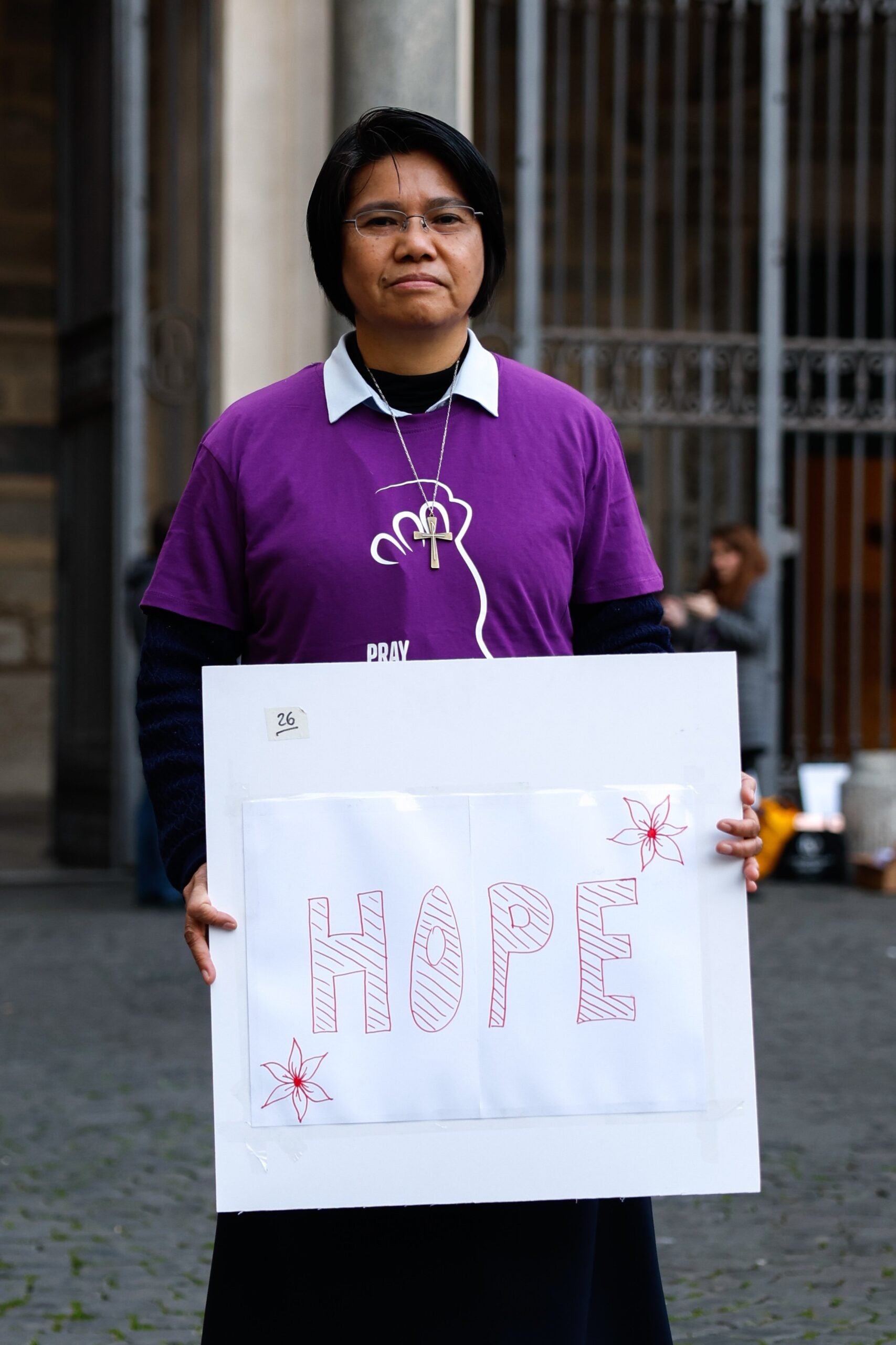 La hermana Maryknoll Abby Avelino posa para una foto sosteniendo un cartel en el que se lee “Esperanza” en la céntrica plaza Santa María in Trastevere de Roma el 6 de febrero de 2024. La hermana Avelino es la coordinadora internacional de Talitha Kum, una red internacional de religiosas que trabajan contra la trata de seres humanos. (Foto CNS/Lola Gomez)