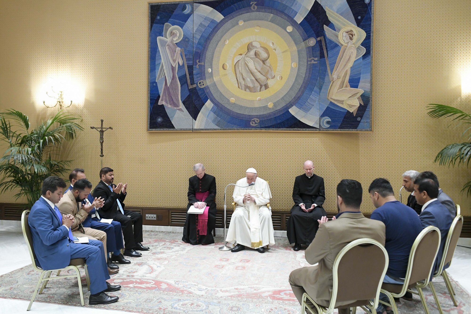 El Papa Francisco y miembros de la Asociación de la Comunidad Afgana en Italia recitan oraciones en una sala de reuniones detrás del Aula de Audiencias Pablo VI en el Vaticano el 7 de agosto de 2024. (Foto CNS/Vatican Media)