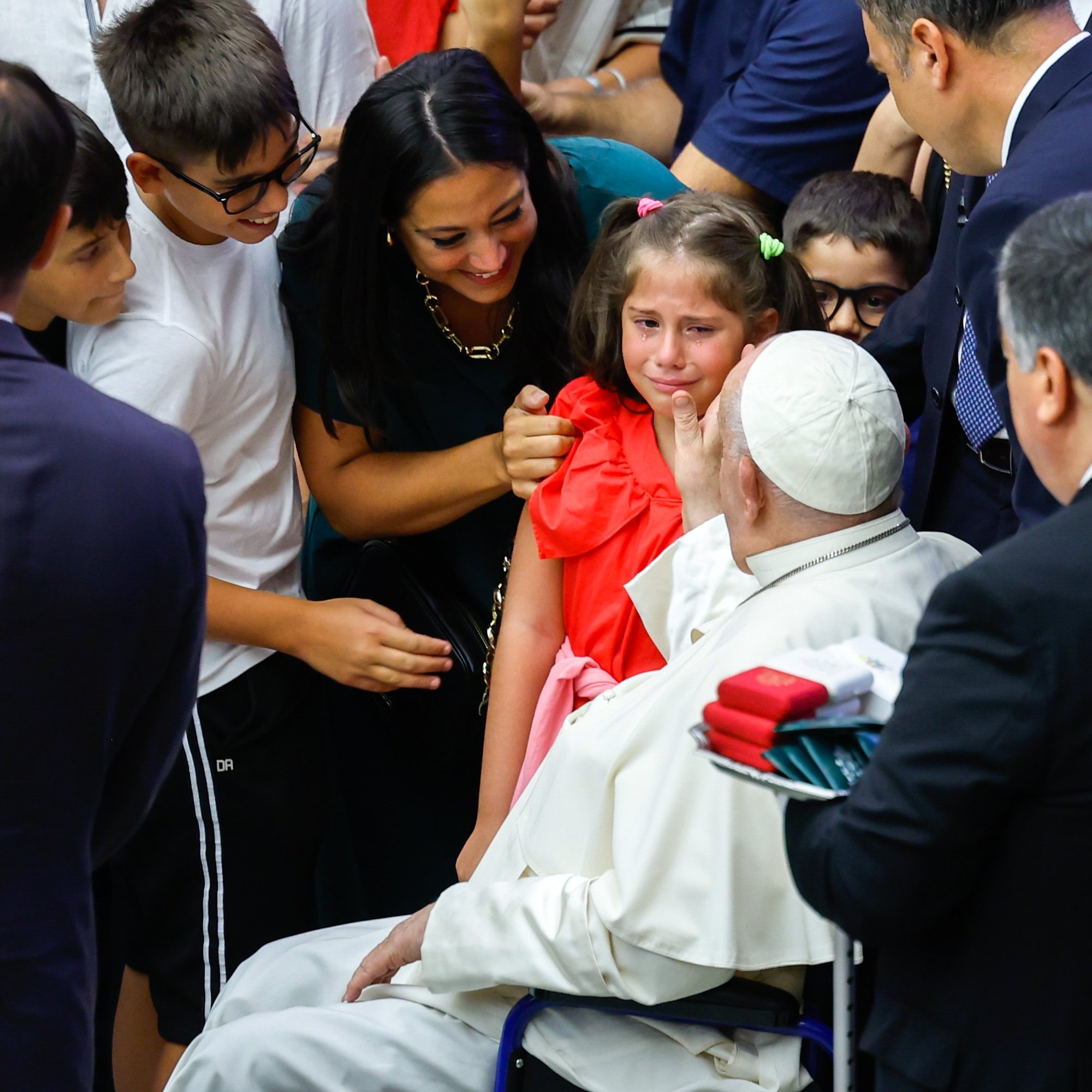 El Papa Francisco consuela a un niño que llora al término de su audiencia general semanal en la Sala de Audiencias Pablo VI del Vaticano el 21 de agosto de 2024. (CNS photo/Lola Gomez)