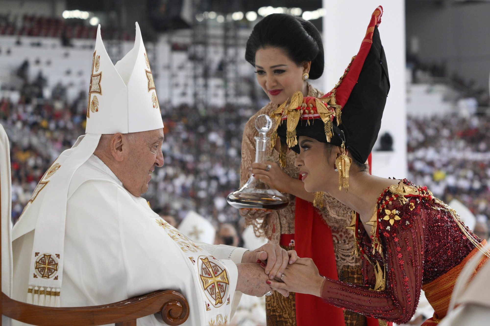 El Papa Francisco recibe vino de manos de mujeres vestidas con trajes tradicionales indonesios durante la entrega de regalos mientras celebra misa en el estadio Gelora Bung Karno de Yakarta, Indonesia, misa del 5 de septiembre de 2023. (CNS photo/Vatican Media)