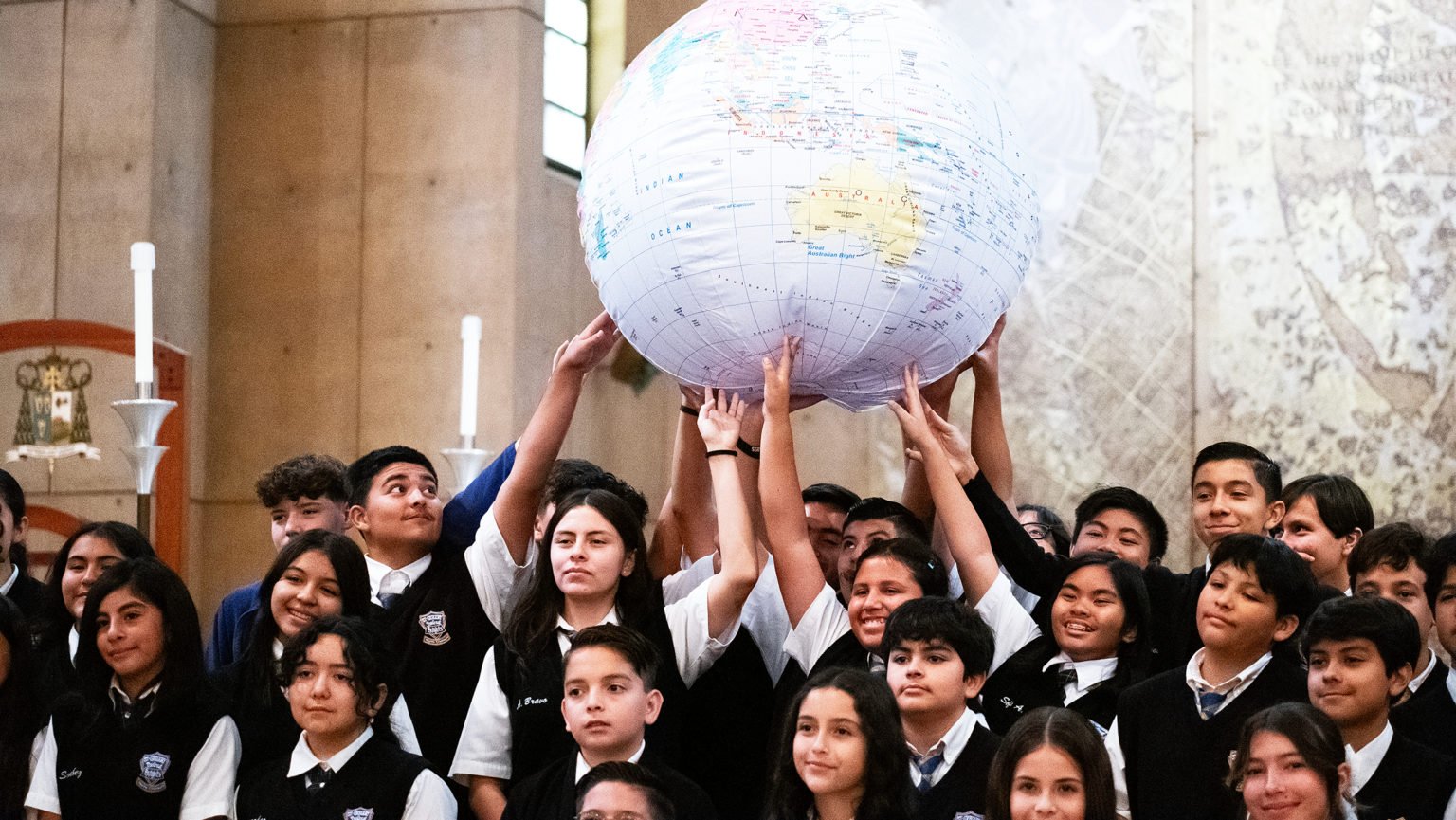 Los estudiantes sostienen un globo inflable después de la misa anual de agradecimiento a los jóvenes de la Asociación de Infancia Misionera el 16 de octubre. (Víctor Alemán)