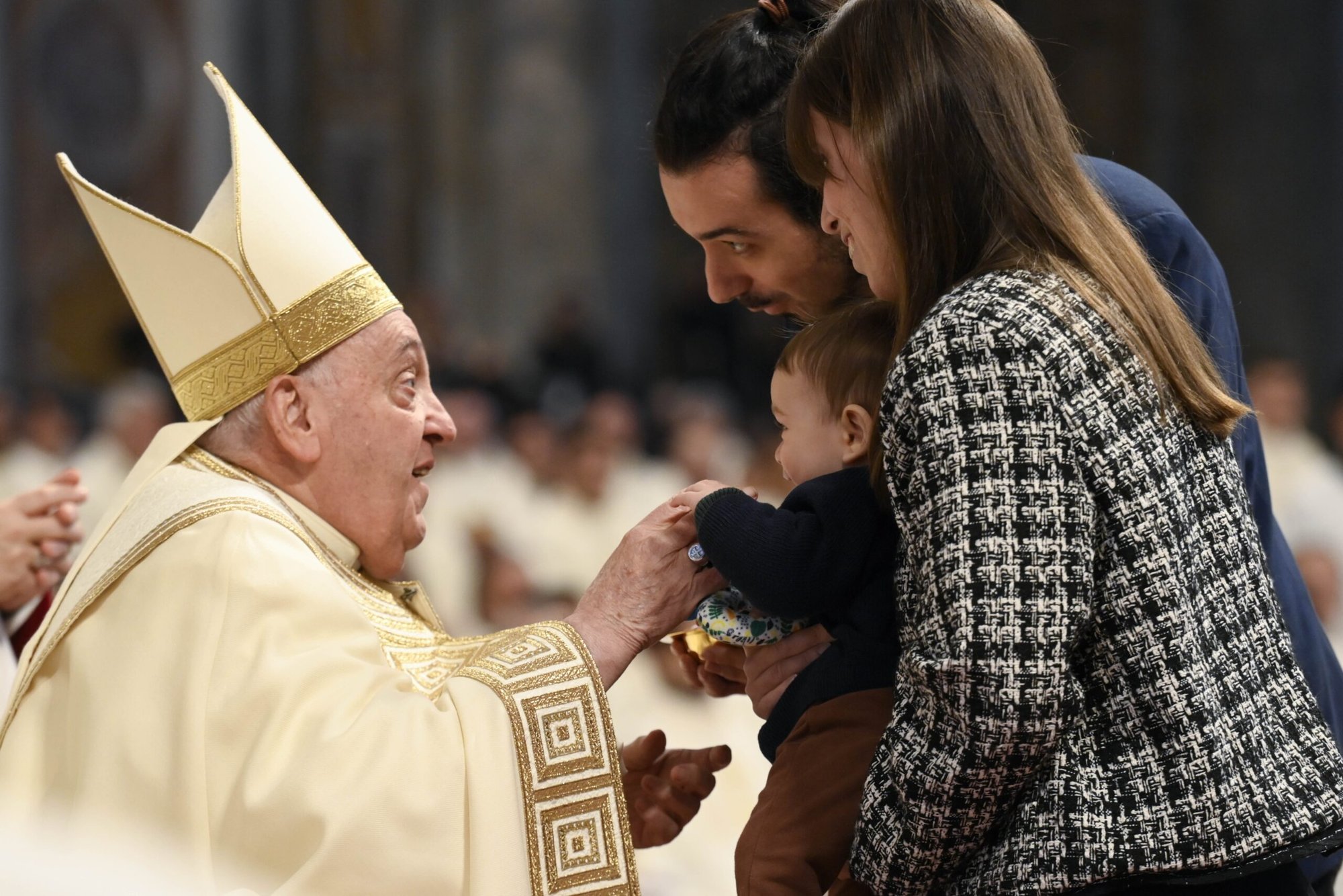 El Papa Francisco interactúa con un niño mientras sus padres presentan las ofrendas durante la Misa en la fiesta de Cristo Rey y la celebración local de la Jornada Mundial de la Juventud en la Basílica de San Pedro en el Vaticano el 24 de noviembre de 2024. (Foto CNS /Vatican Media)