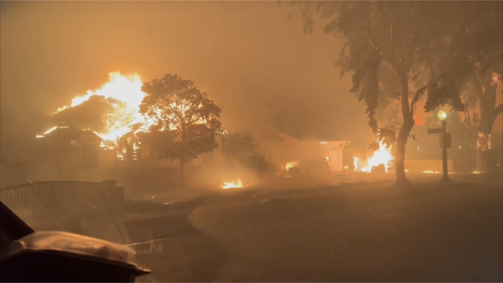 Casas arden por el incendio de Palisades en Sunset Boulevard cerca de la Iglesia Católica Corpus Christi en Pacific Palisades la noche del martes 7 de enero de 2024. (Angelus News)
