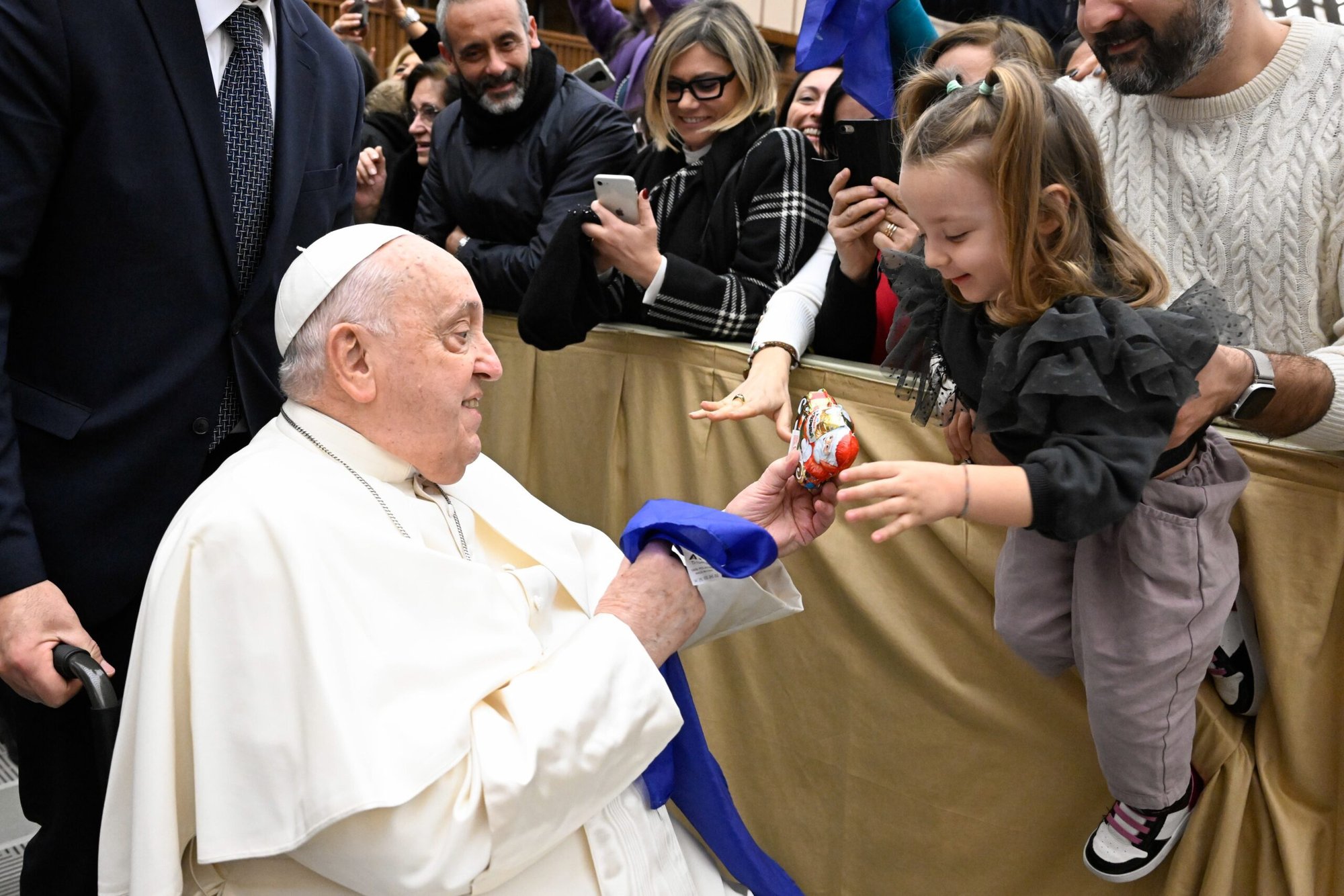 El Papa Francisco entrega un Papá Noel de chocolate a un niño durante una reunión con un sindicato católico italiano de profesores y personal escolar, una asociación italiana de profesores católicos y una asociación de padres de escuelas católicas en el Aula de Audiencias Pablo VI del Vaticano el 4 de enero de 2025. (CNS photo/Vatican Media)