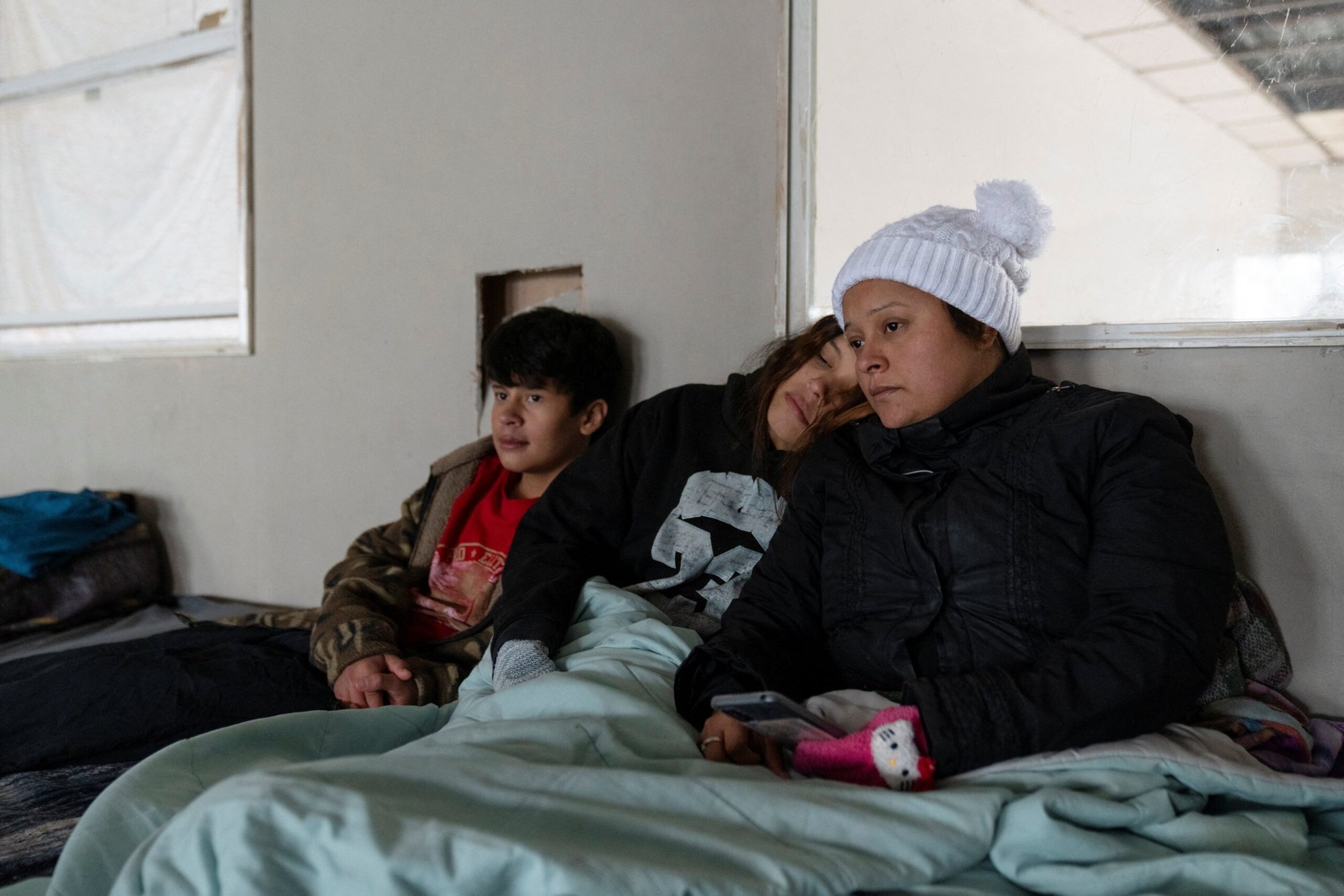 Una mujer hondureña, Denia Méndez, de 32 años, su hija Sofía, de 15, y su hijo Isaí, de 13, sentados en su cama en un refugio para migrantes en Piedras Negras, México, el 20 de enero de 2025, día de la toma de posesión de Donald Trump, investido para su segundo mandato presidencial. Los tres han buscado asilo en Estados Unidos durante los últimos 13 meses y recibieron un correo electrónico de la Oficina de Aduanas y Protección Fronteriza de Estados Unidos en el que se les informaba que su cita con la CBP programada para el 21 de enero había sido cancelada. (Foto OSV News/Cheney Orr, Reuters)