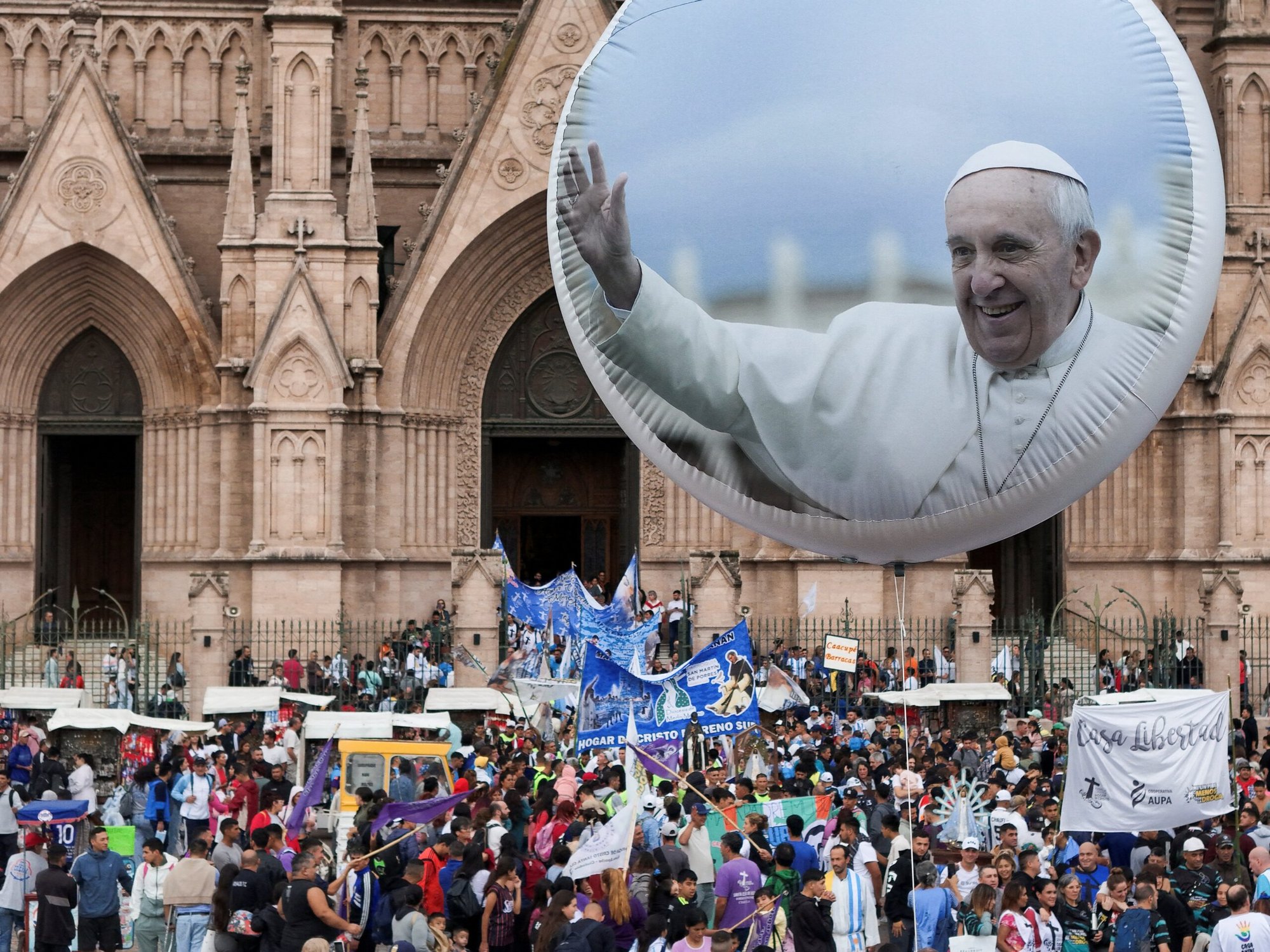 Un globo con una imagen del Papa Francisco se ve mientras miles de fieles se reúnen para asistir a una misa en la Basílica de Luján en la provincia de Buenos Aires, Argentina, 16 de marzo de 2025, para orar por el Papa, quien sigue su tratamiento para la neumonía bilateral en el Hospital Gemelli de Roma, donde está hospitalizado desde el 14 de febrero. El Vaticano confirmó que el pontífice, de 88 años, concelebró la Misa en la capilla del hospital el 16 de marzo. (Foto OSV News/Martin Cossarini, Reuters)