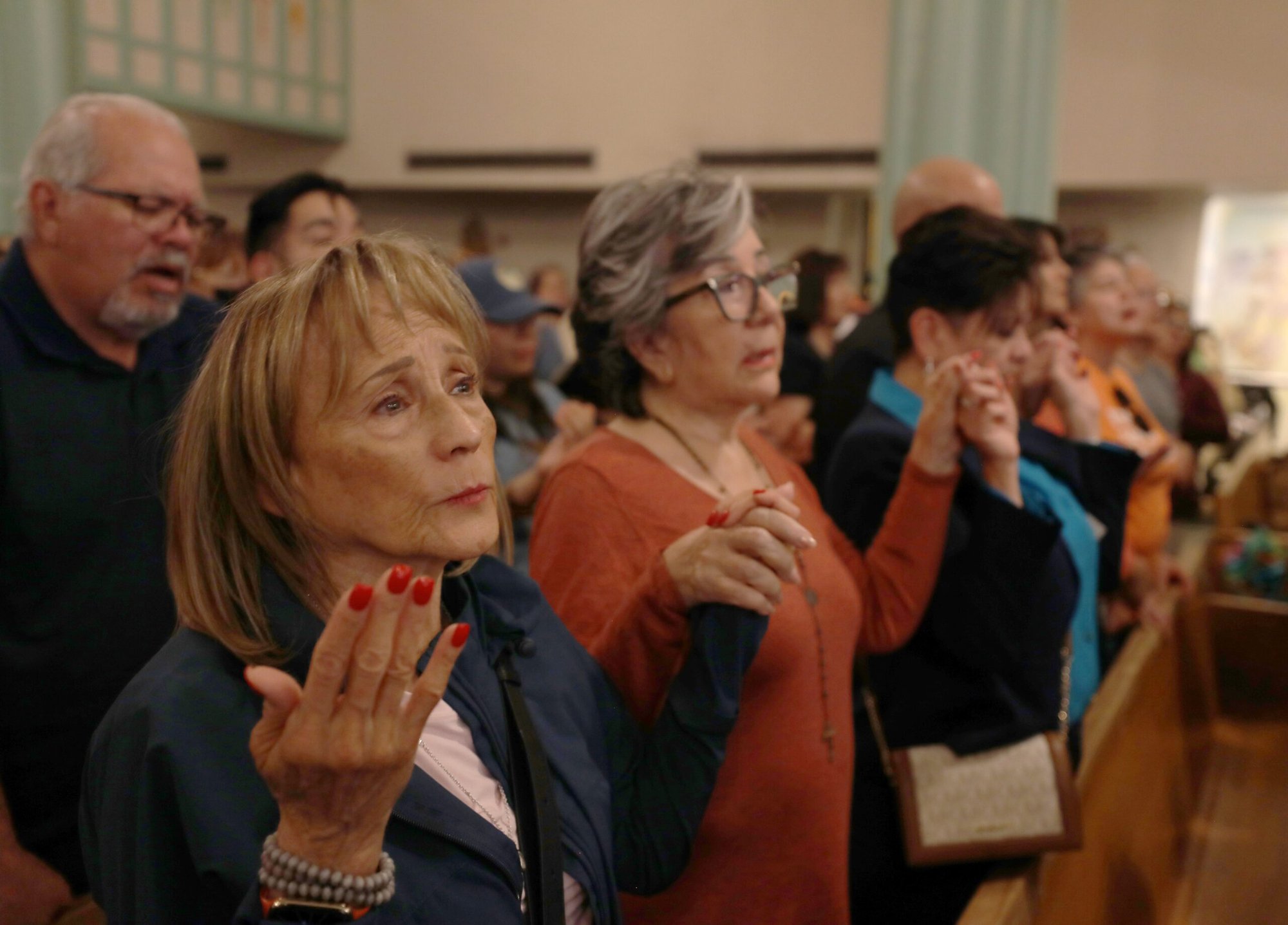 Un grupo de personas se dan la mano mientras el obispo de El Paso, Texas, Mark J. Seitz, dirige una vigilia de oración en la iglesia del Sagrado Corazón de El Paso el 24 de marzo de 2025, tras una concentración y una marcha de protesta contra las deportaciones masivas llevadas a cabo por el gobierno de EE.UU. (Foto OSV News/Bob Roller)