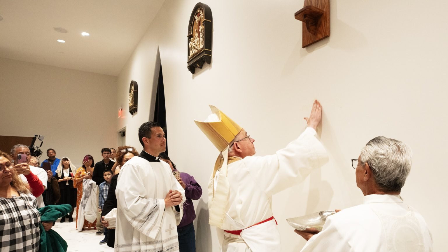 El arzobispo José H. Gomez unge las paredes de la nueva iglesia Ángel Guardián en Pacoima durante la Misa de dedicación del 4 de abril de 2025. El cardenal Roger Mahony, el obispo auxiliar Albert Bahhuth y el obispo emérito Gerald Wilkerson también ayudaron a ungir las paredes durante el Rito de Dedicación. (Victor Alemán)