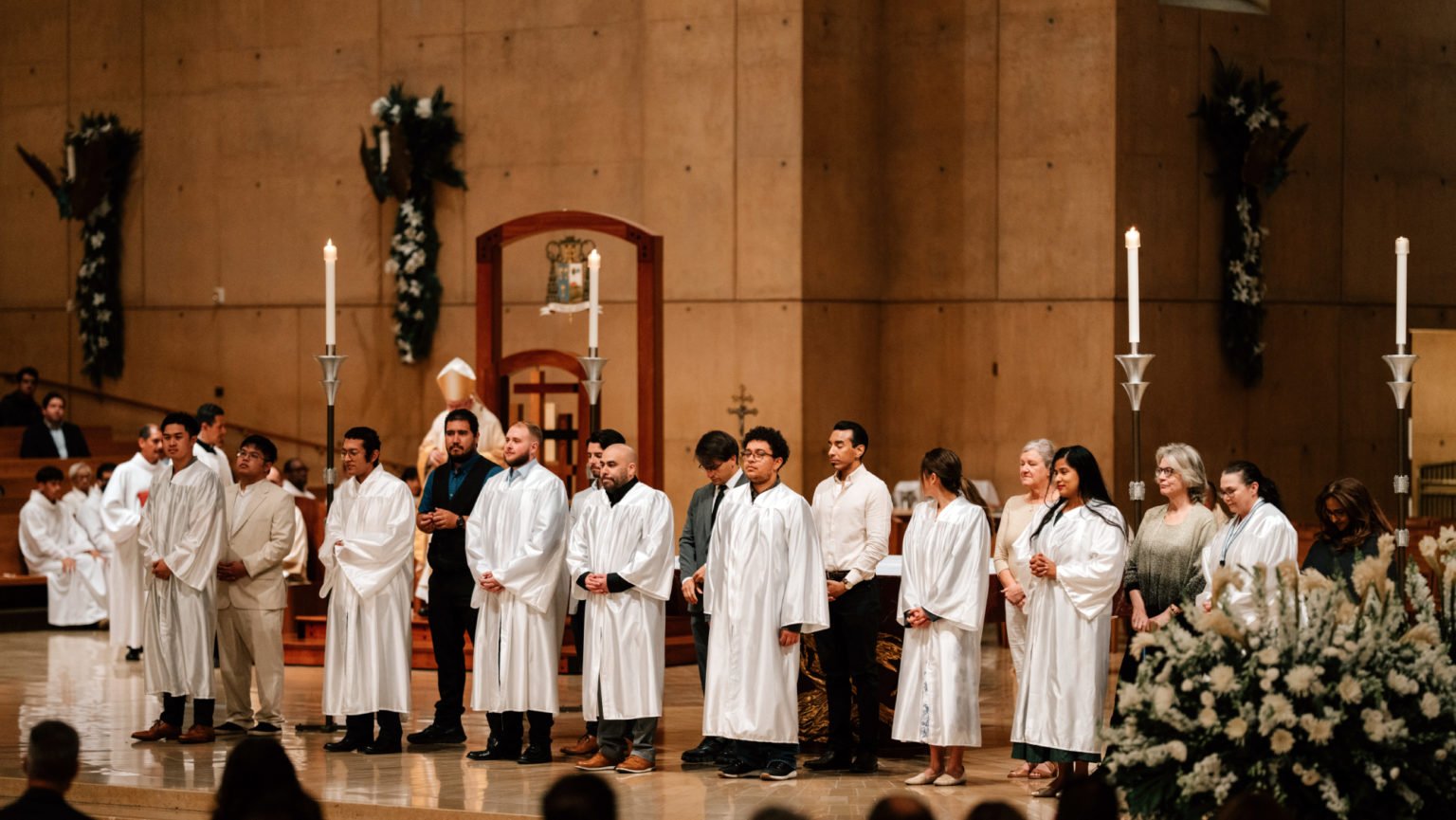 Catecúmenos recién bautizados se colocan en el altar de la Catedral de Nuestra Señora de los Ángeles durante la Vigilia Pascual el 19 de abril. (Peter Lobato)