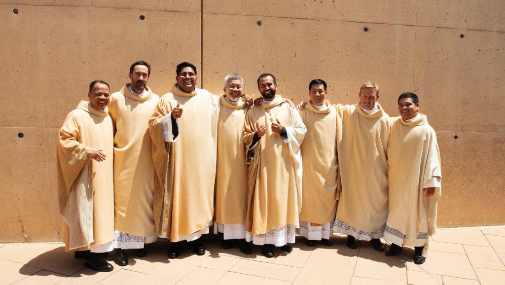 Los recién ordenados Padres Allan Carodan, Michael Croghan, Jorge Moncada, Joseph Cruz, Christian Morquecho, Quoc Vo, Paul Collins y Johndy Gonzales comparten un momento de alegría tras la Misa de ordenación del 31 de mayo. (Victor Alemán)
