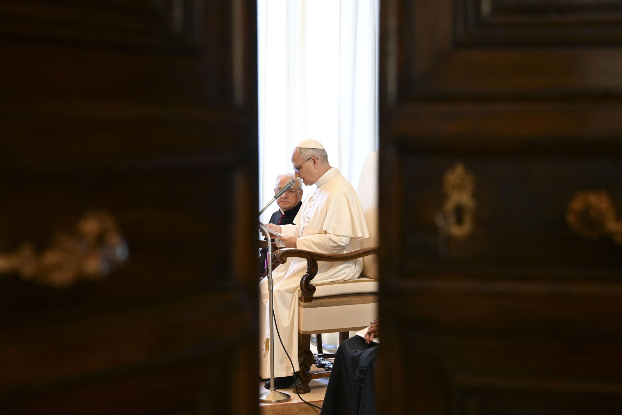 El Papa León XIV es visto a través de una puerta abierta mientras se reúne con representantes de la Sociedad de Misiones Africanas, la Tercera Orden Regular de San Francisco y formadores y miembros de las Siervas del Paráclito durante una audiencia en el Vaticano el 6 de junio de 2025. (CNS photo/Vatican Media)