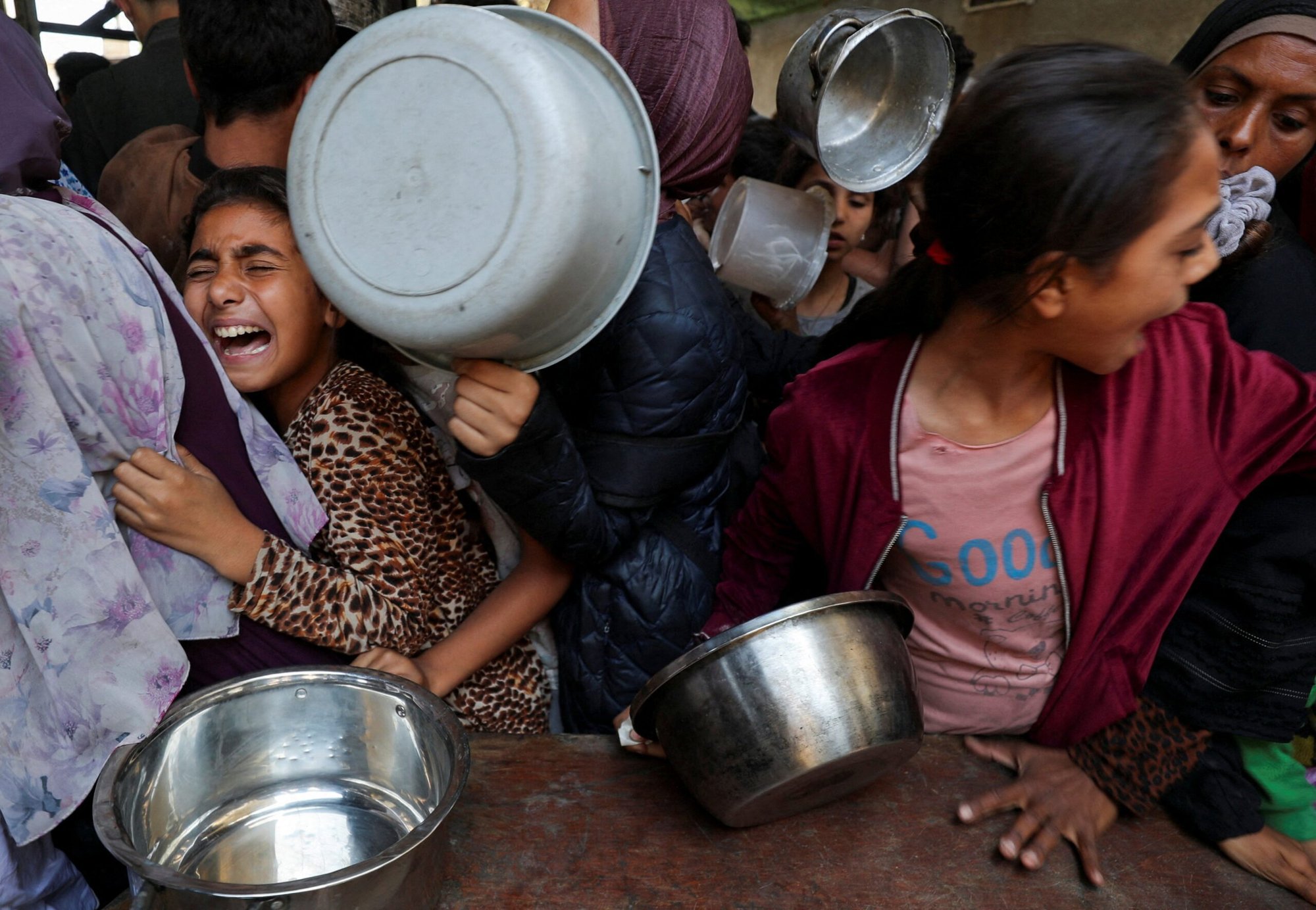 Una niña palestina desplazada por la ofensiva militar israelí reacciona mientras espera con otros jóvenes el 21 de mayo de 2025 para recibir alimentos cocinados por una cocina de caridad en la ciudad de Gaza, Franja de Gaza. (Foto de OSV News/Mahmoud Issa, Reuters)