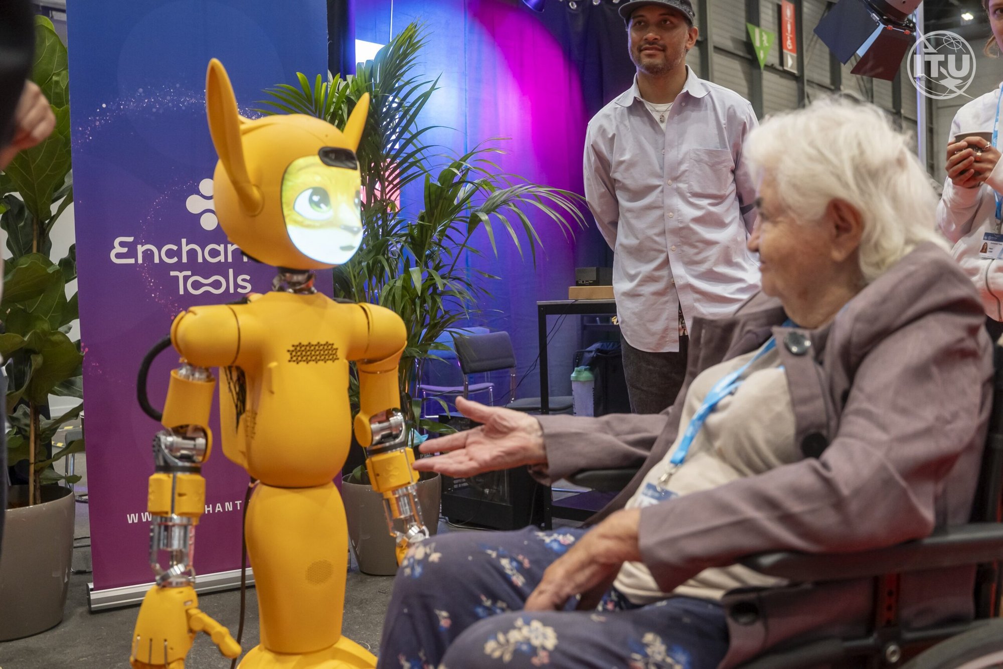 Una mujer en silla de ruedas tiende la mano a Mirokaï, una nueva generación de robots que emplea Inteligencia Artificial, como se ve en esta foto tomada el 8 de julio de 2025, en la Cumbre AI for Good 2025 en Ginebra. La cumbre, celebrada del 8 al 11 de julio y organizada por la Unión Internacional de Telecomunicaciones en colaboración con unos 40 organismos de las Naciones Unidas y el gobierno suizo, se centró en "identificar aplicaciones innovadoras de la IA, crear competencias y normas, y promover asociaciones para resolver los retos mundiales", según el sitio web del evento. (CNS photo/cortesía de la UIT/Rowan Farrell)