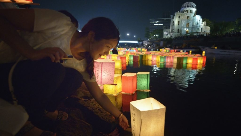 Una mujer coloca una linterna flotante en el río el 6 de agosto de 2015, en Hiroshima, Japón, en conmemoración del 70 aniversario del bombardeo atómico de la ciudad. Los obispos católicos de Japón piden la prohibición de las armas nucleares mientras anuncian un programa de oración de 10 días para conmemorar el aniversario de los bombardeos de Hiroshima y Nagasaki. (CNS photo/Paul Jeffrey)