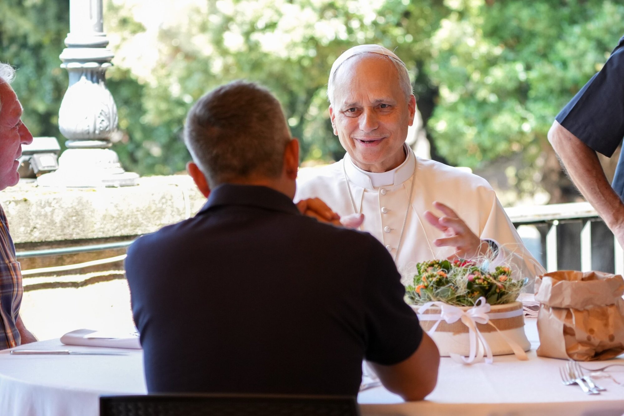 El Papa León XIV habla con un invitado que es parte de un grupo de personas asistidas por la agencia Cáritas diocesana de Albano durante un almuerzo en el Borgo Laudato Si' en Castel Gandolfo, Italia, 17 de agosto de 2025. El encuentro tuvo lugar tras una Misa que el Papa celebró ese mismo día en Albano Laziale. (Foto CNS/Lola Gomez)