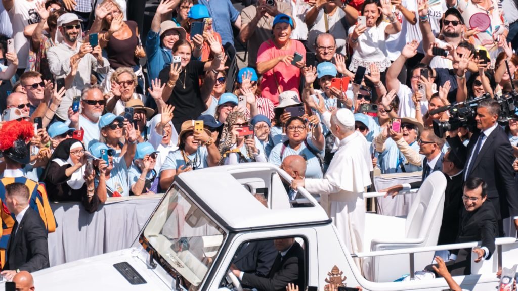 Evelyn Moreira (al centro, sosteniendo el rosario) y otros peregrinos de Los Ángeles con camisetas azules saludan al Papa León XIV después de la Misa de canonización de los santos Pier Giorgio Frassati y Carlo Acutis el 7 de septiembre en la Plaza de San Pedro. (Isabel Cacho/Arquidiócesis de LA)