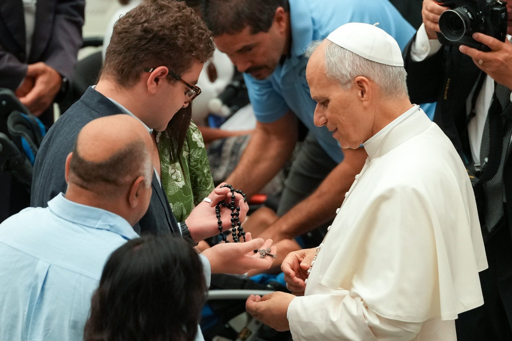 El papa León XIV saluda a un joven que sostiene un rosario durante su audiencia general en la sala Pablo VI del Vaticano, el 13 de agosto de 2025. (Foto CNS/Vatican Media)