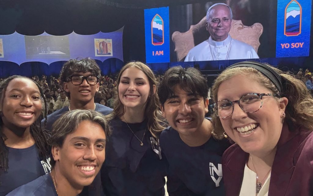 Mia Smothers, Chris Pantelakis, Micah Alcisto, Elise Wing y Ezequiel Ponce posan con la moderadora Katie Prejean McGrady, derecha, para tomarse una “selfie” con el Papa León XIV durante un encuentro digital en vivo en el estadio Lucas Oil en Indianápolis el 21 de noviembre. (CNA/Katie Prejean McGrady)