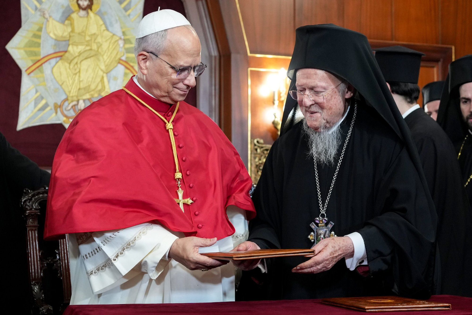 El papa León XIV y el patriarca ecuménico ortodoxo Bartolomé de Constantinopla se entregan mutuamente copias de una declaración conjunta que firmaron el 29 de noviembre de 2025, al término de un servicio religioso en la catedral patriarcal de San Jorge en Estambul. (Foto CNS/Lola Gómez)