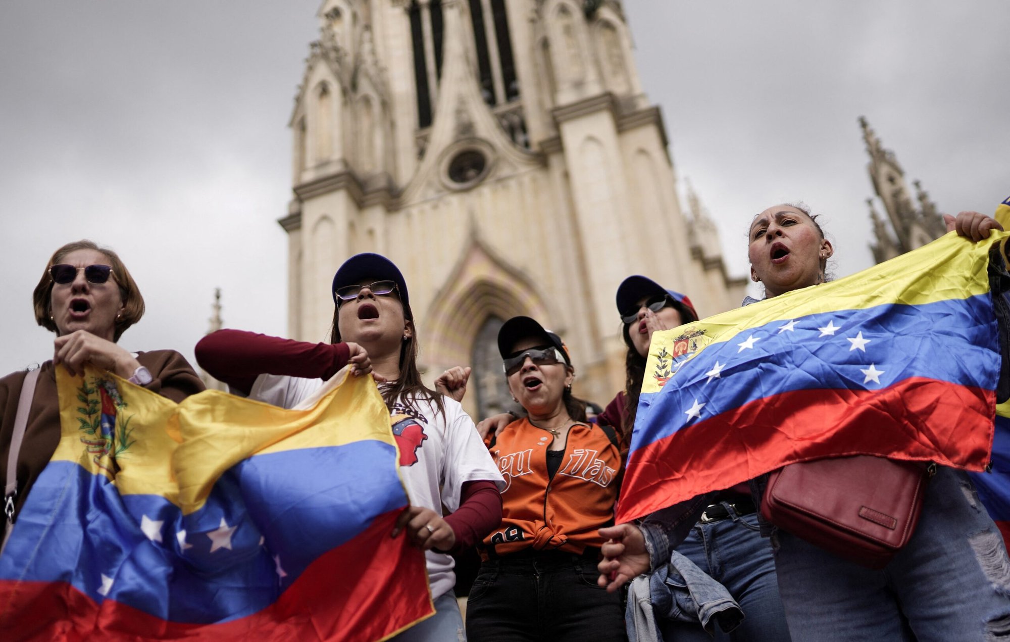 Varias personas ondean banderas venezolanas mientras participan de una manifestación frente a la Basílica Menor de Nuestra Señora de Lourdes en Bogotá el 4 de enero de 2026, pidiendo una transición democrática, tras los ataques lanzados por Estados Unidos contra Venezuela, que resultaron en la captura del presidente Nicolás Maduro y su esposa, Cilia Flores. (Foto OSV News/Sergio Acero, Reuters)