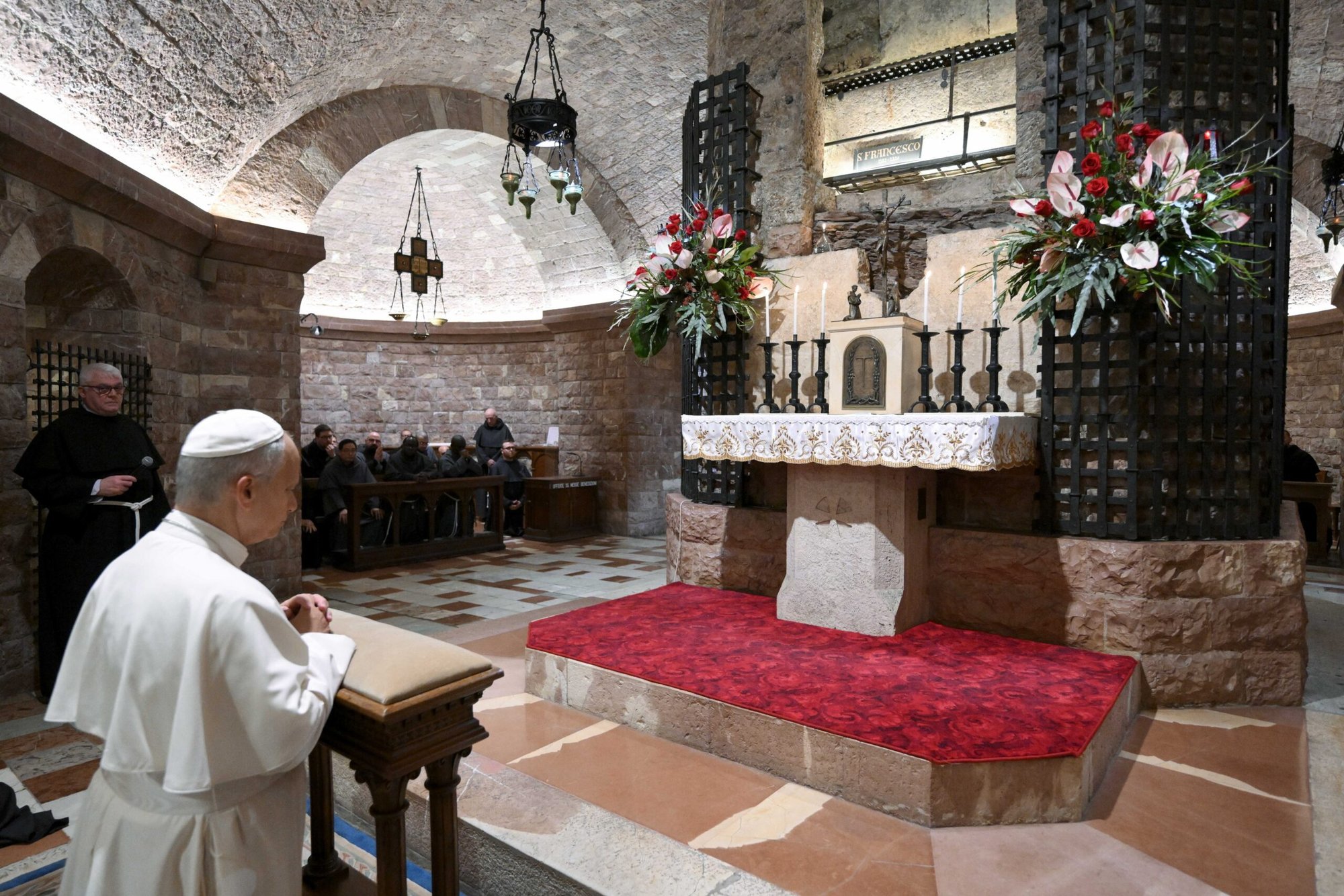 El papa León XIV y los frailes franciscanos rezan ante la tumba de San Francisco en la Basílica de San Francisco de Asís, Italia, el 20 de noviembre de 2025. (Foto CNS/Vatican Media)