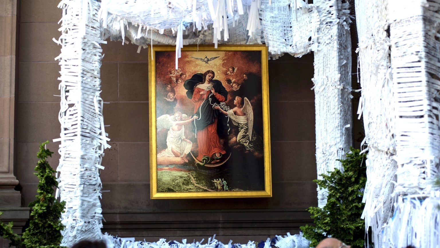 Una pintura de María Desatanudos cuelga dentro de la “Gruta de los Nudos” en la Basílica Catedral de los Santos Pedro y Pablo en Filadelfia durante el Encuentro Mundial de las Familias. El proyecto invita a los visitantes a escribir sus intenciones de oración en tiras blancas y atarlas a la estructura. (CNS/Carley Mossbrook)