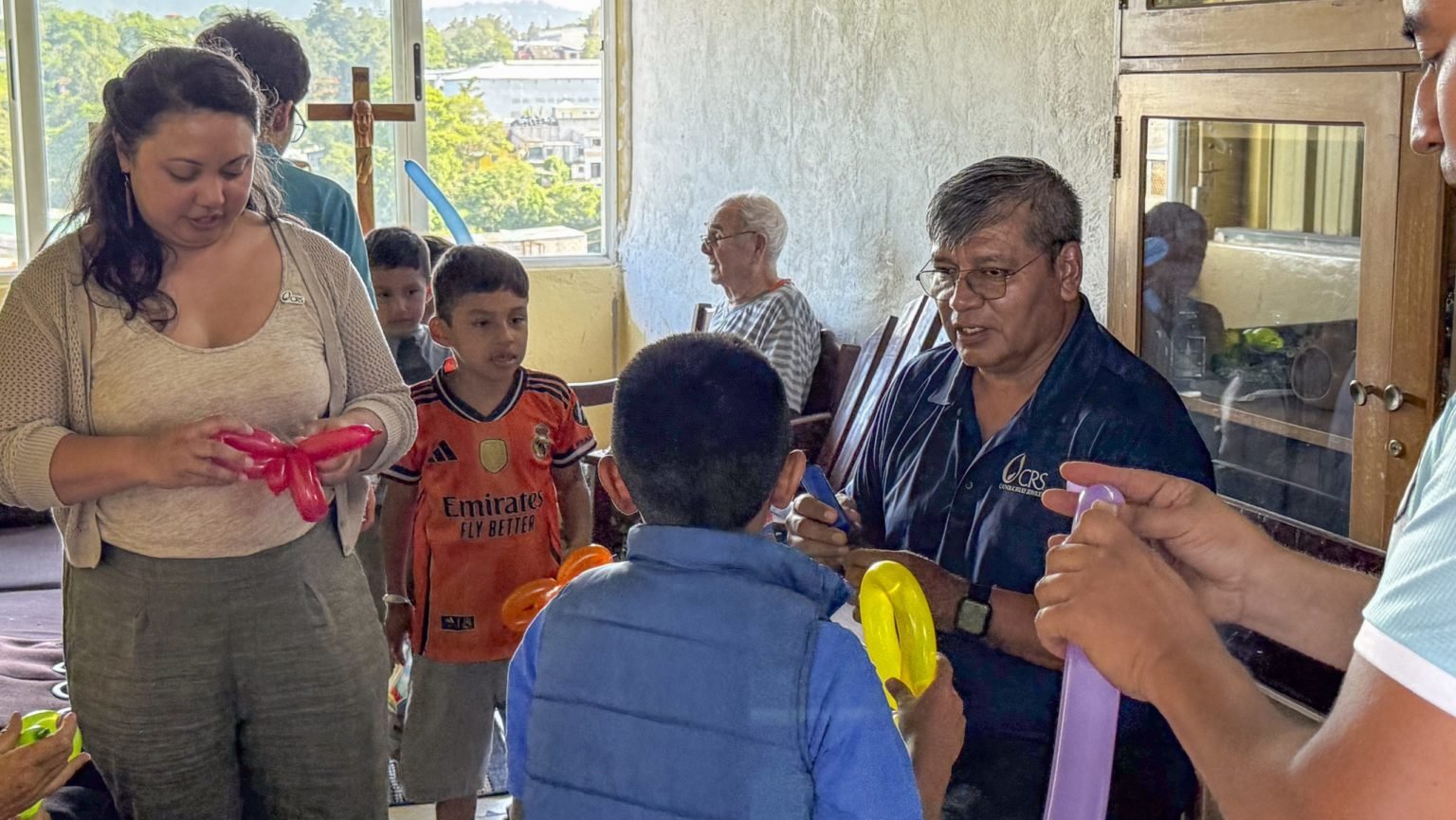 Heidi Villaluz, izquierda, feligresa del St. Camillus Center for Spiritual Care en Los Ángeles, ayuda a un miembro del personal de Catholic Relief Services en el centro Caminando por la Paz en Guatemala a prepararse para una celebración con niños. (Heidi Villaluz)