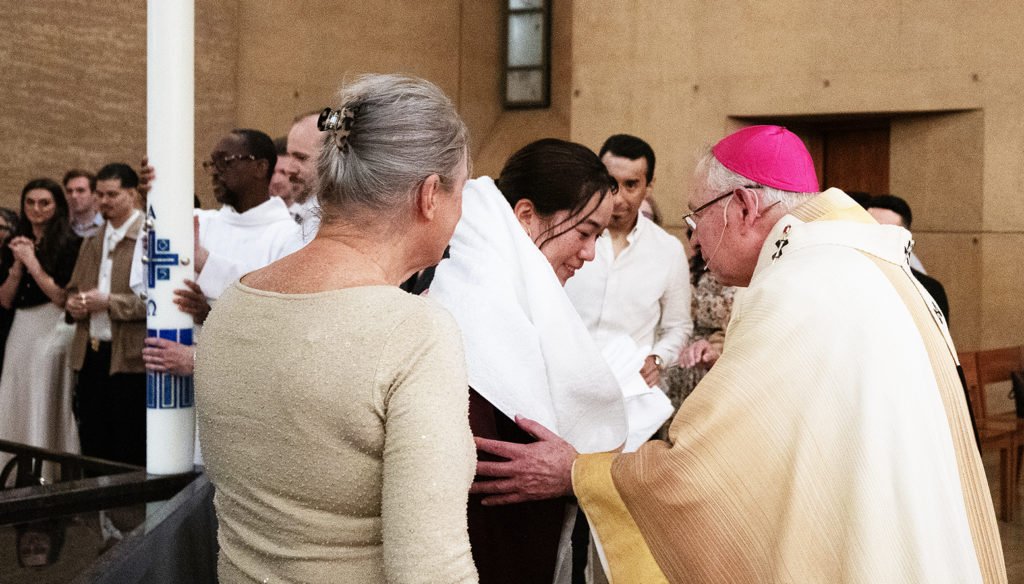 El arzobispo José H. Gómez saluda a un católico de Los Ángeles recién bautizado durante la Vigilia Pascual de 2025 en la Catedral de Nuestra Señora de los Ángeles. (Víctor Alemán)