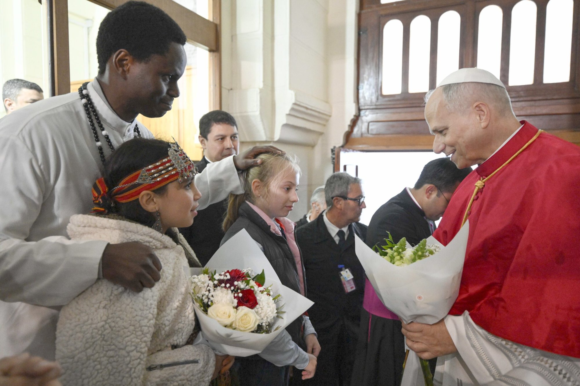El papa León XIV saluda a un hombre y a unas jóvenes durante una reunión con la comunidad argelina en la basílica de Nuestra Señora de África, en Argel (Argelia), el 13 de abril de 2026. (Foto de OSV News/Simone Risolutie, Vatican Media)