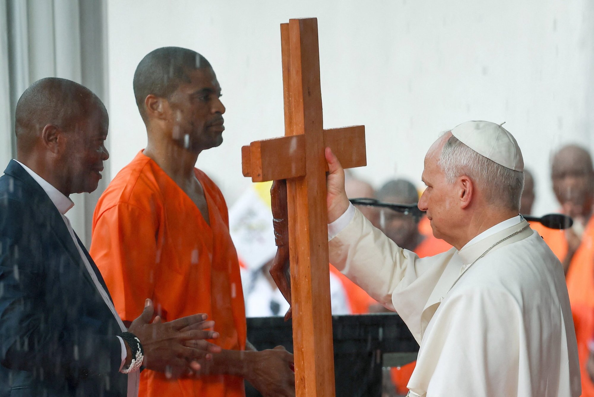 El papa León XIV recibe una cruz de manos de un recluso durante la visita del pontífice a la prisión de Bata, en Guinea Ecuatorial, el 22 de abril de 2026. (Foto de OSV News/Guglielmo Mangiapane, Reuters)