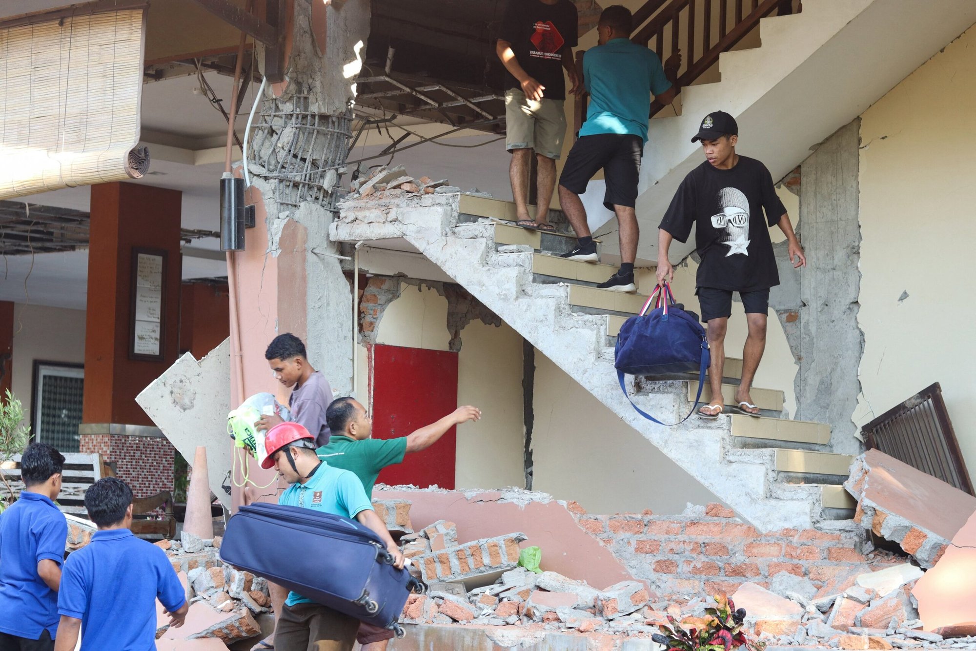 Personas son evacuadas tras el derrumbe de un edificio del hotel Jayakarta luego de un terremoto de magnitud 7,7, en Labuan Bajo, Nusa Tenggara Oriental, Indonesia, el 15 de agosto de 2026. Ese día, un potente terremoto de magnitud 7,7 sacudió la costa oriental del país, dejando más de 50 muertos y miles de personas desplazadas. (Foto de OSV News/Stringer, Reuters)