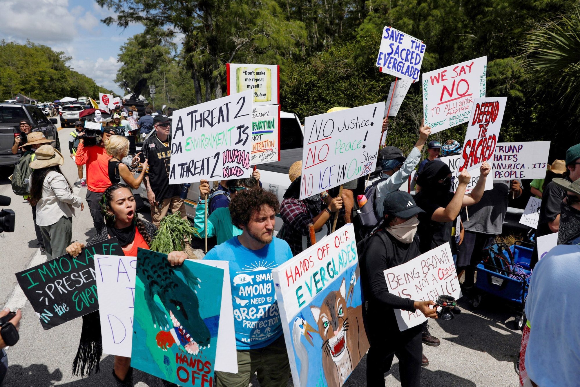 Manifestantes se sitúan a ambos lados de una vía de acceso a un centro temporal de detención de migrantes apodado "Alligator Alcatraz" en Ochopee, Florida, el 1 de julio de 2025, día en que el presidente de EE.UU., Donald Trump, visitó las instalaciones. Líderes católicos están reaccionando ante un informe del Inspector General del Departamento de Seguridad Nacional que revela que "Alligator Alcatraz" confinaba a los migrantes detenidos en celdas de 4 por 7 pies, entre otras prácticas "inhumanas" llevadas a cabo en dicho centro de Florida, que ya ha sido clausurado. (OSV News/Octavio Jones, Reuters)