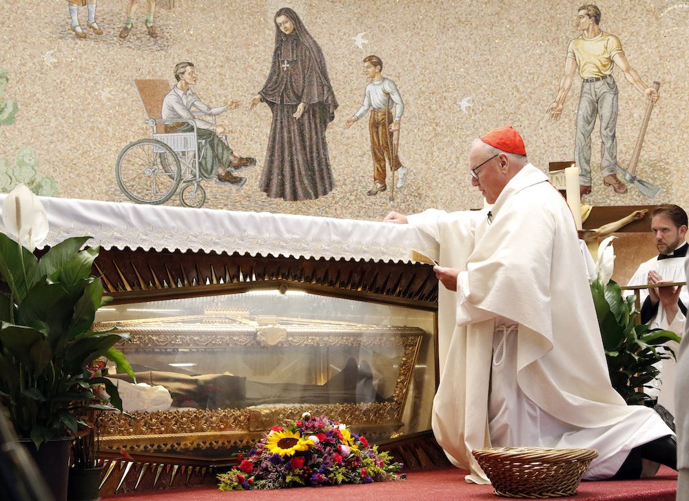 New York Cardinal Timothy M. Dolan prays at the tomb of St. Frances Xavier Cabrini during a Mass for immigrants July 13