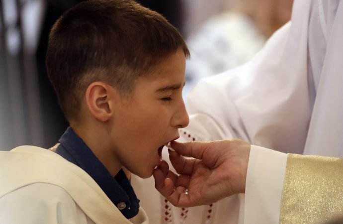Pope Francis gives the Holy Communion to a boy during a Mass in the Church of the Sacred Heart of Rakovsky